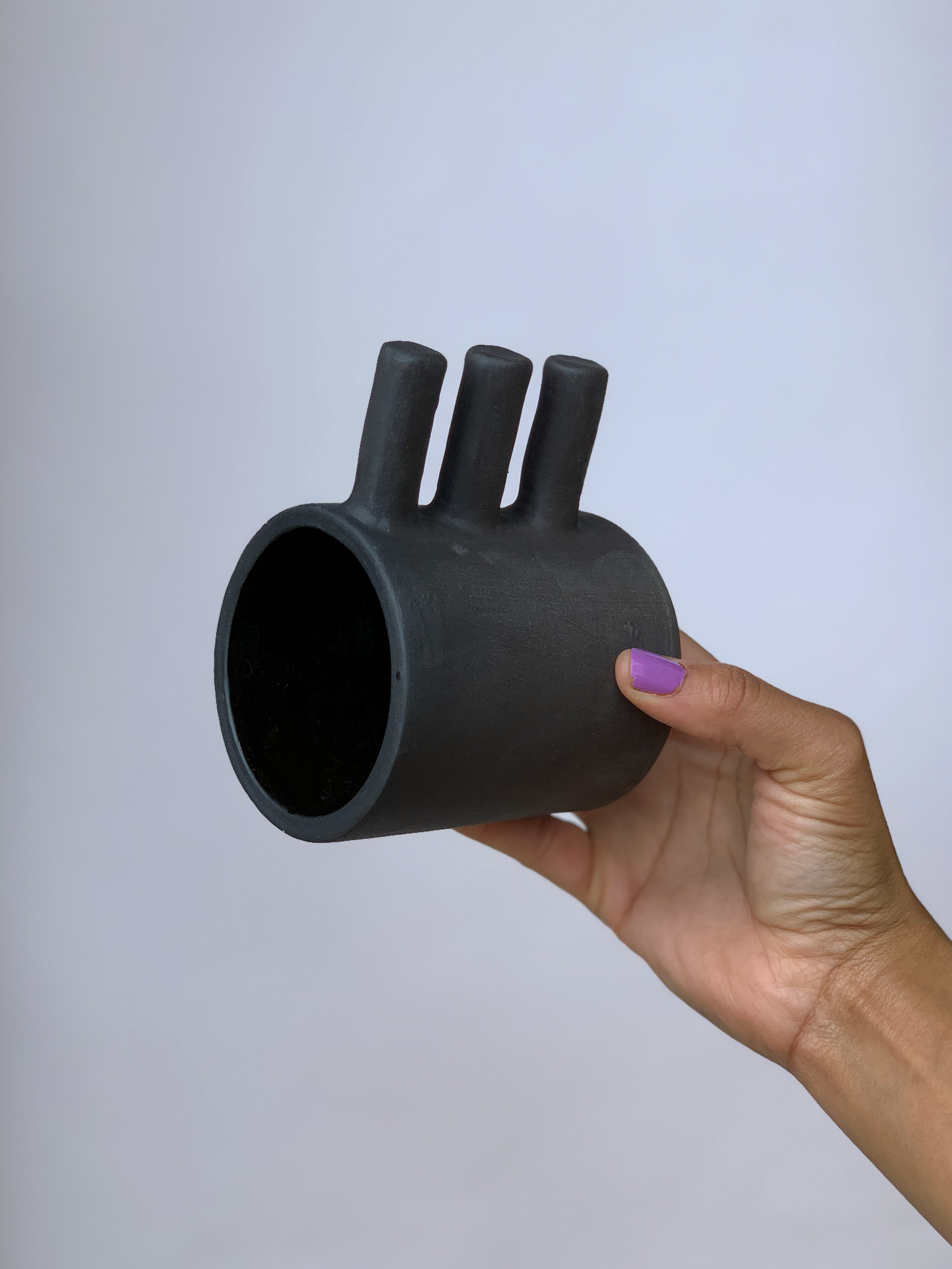 Black matte stoneware ceramic mug with a three bar handle.