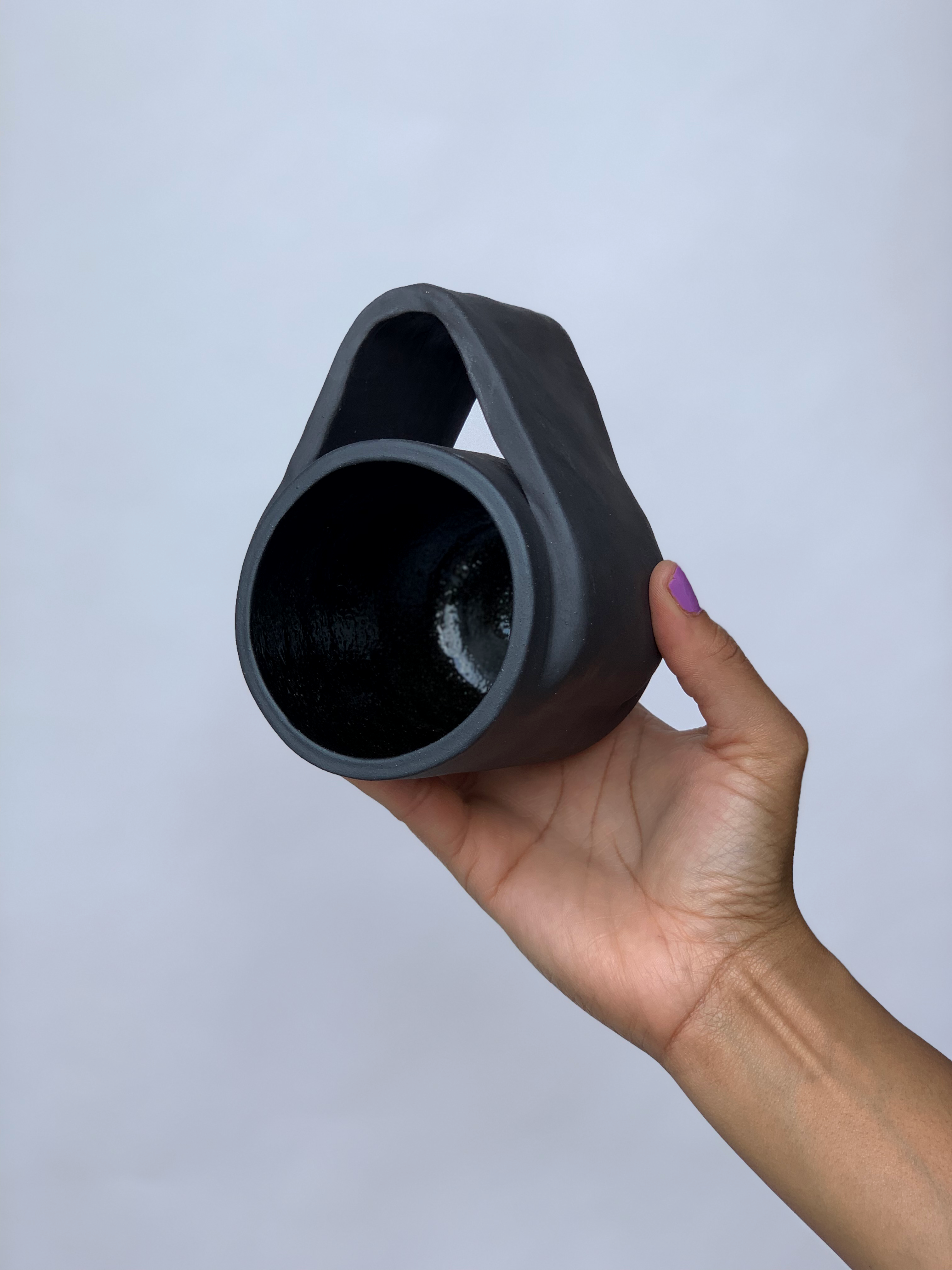 Black matte stoneware ceramic mug with a wide wrap around handle.
