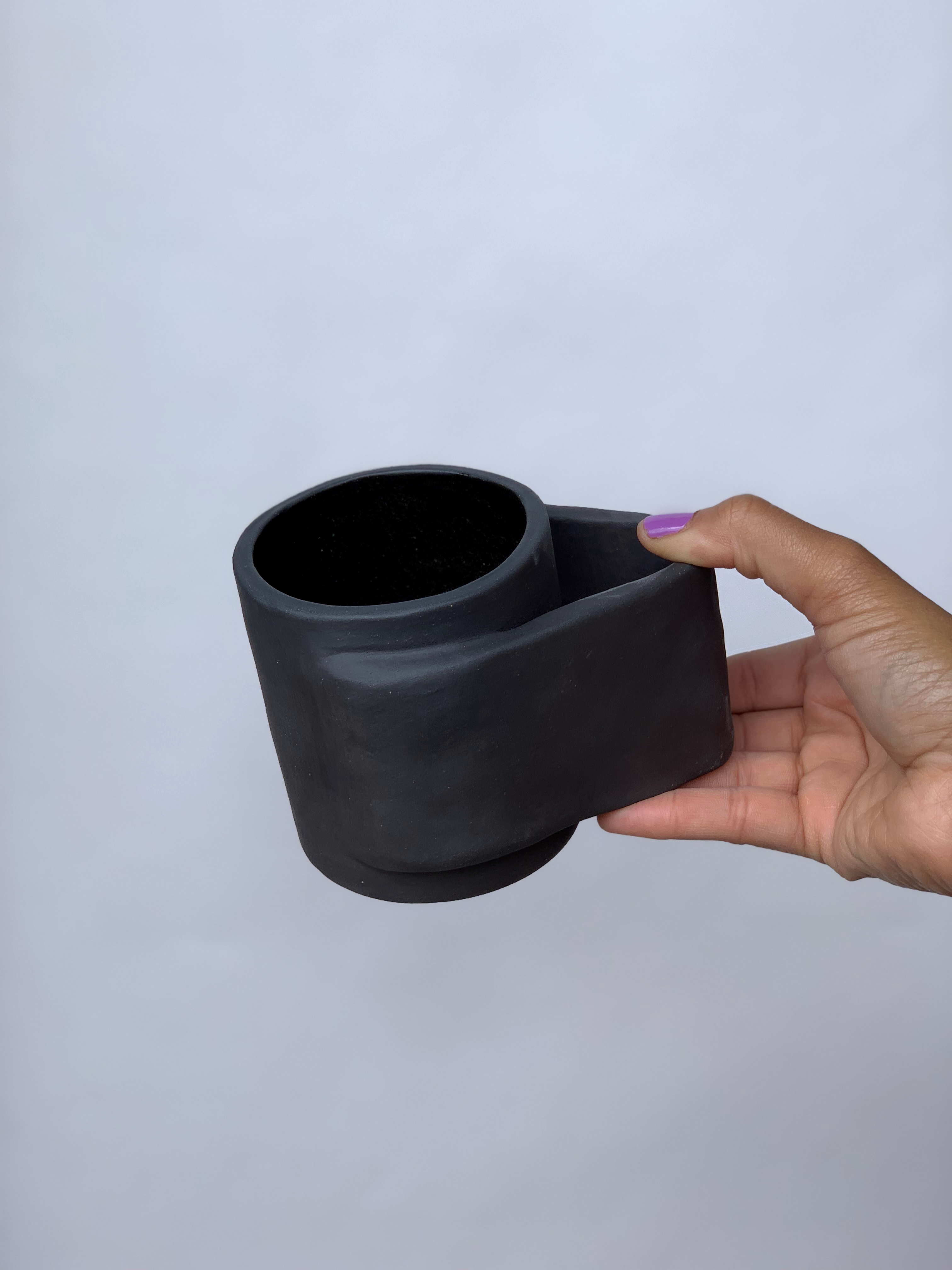 Black matte stoneware ceramic mug with a wide wrap around handle.