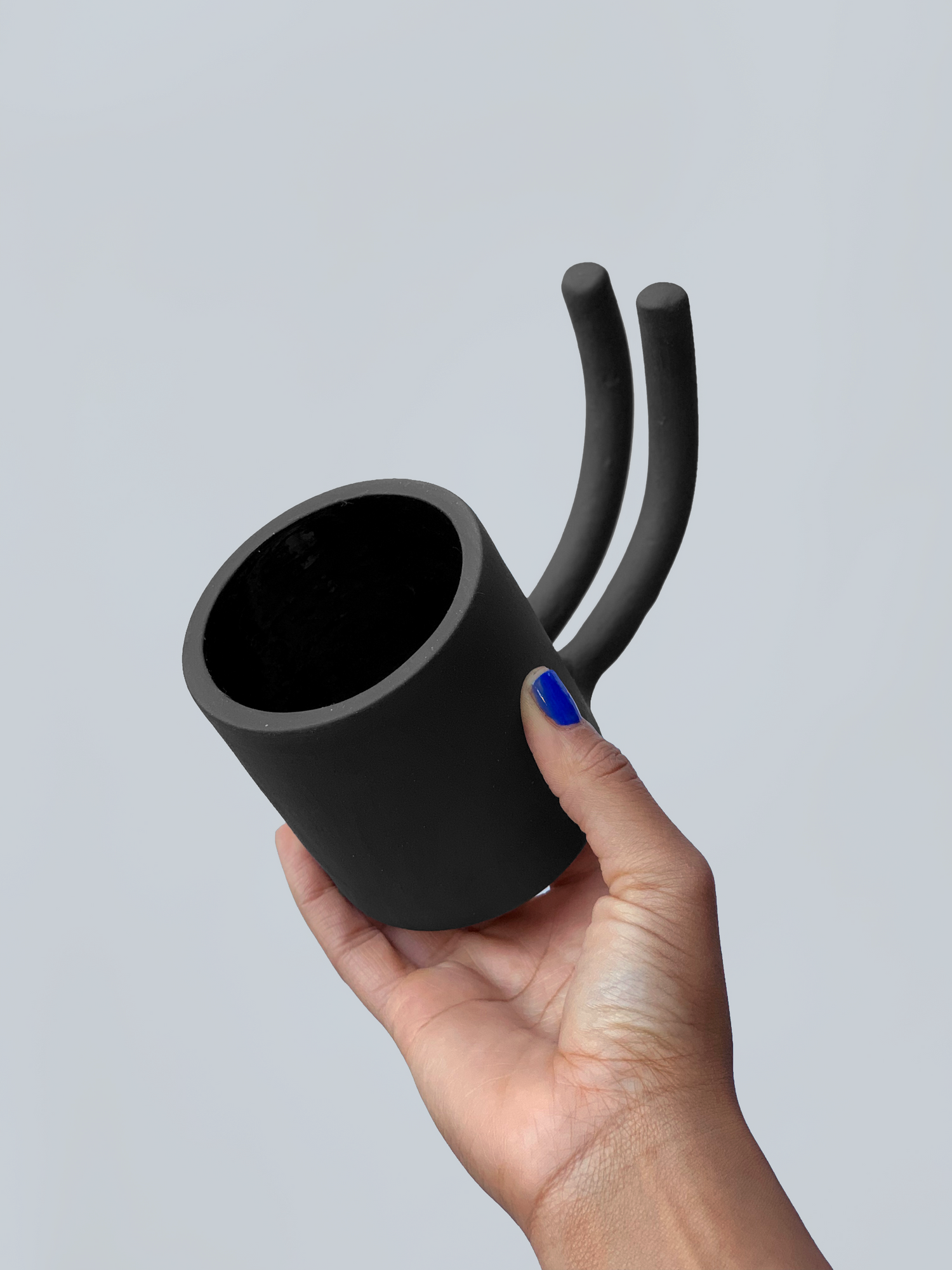 Black matte stoneware ceramic mug with a double prong handle.