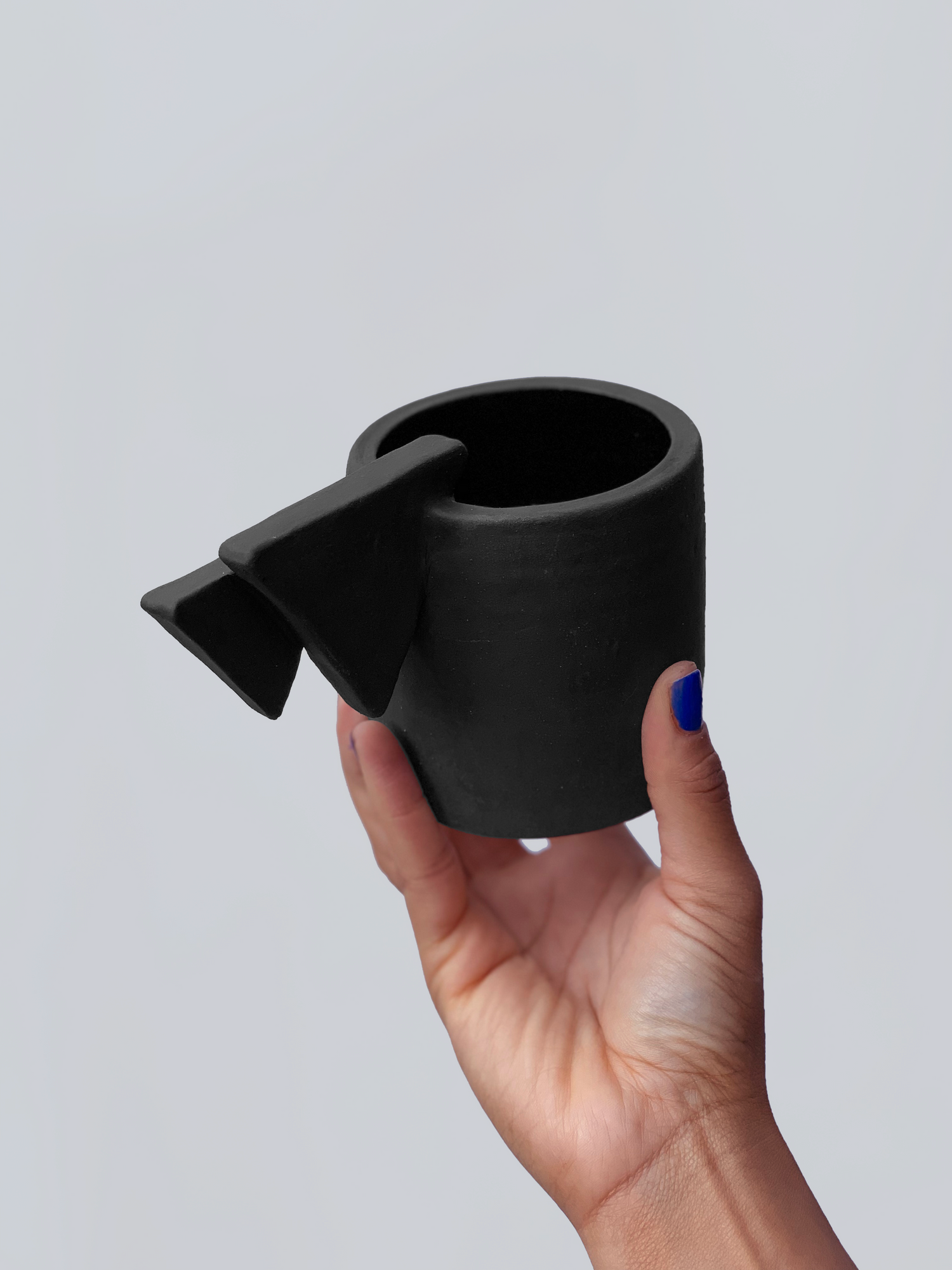 Black matte stoneware ceramic mug with a double layered triangle handle.
