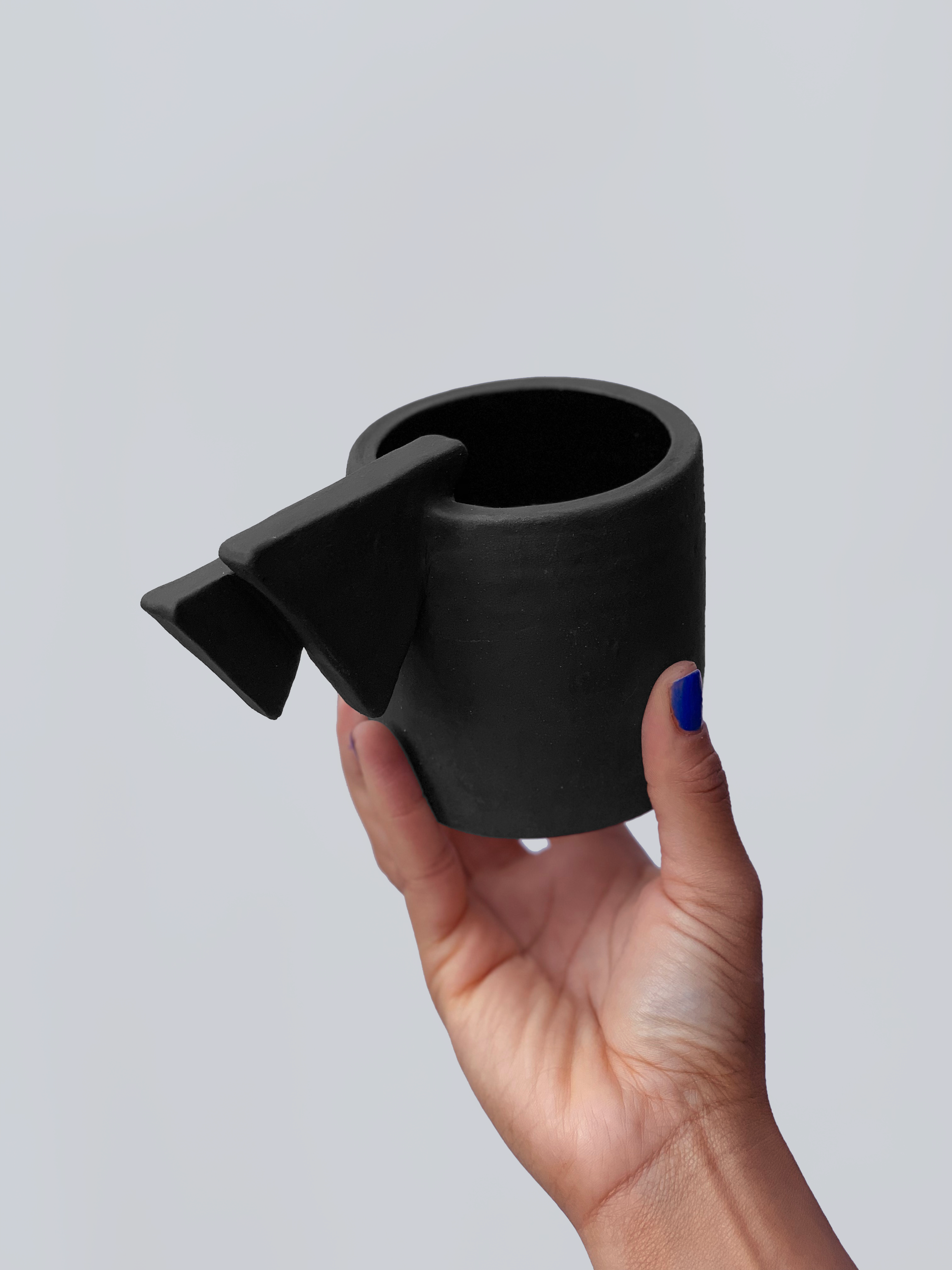 Black matte stoneware ceramic mug with a double layered triangle handle.
