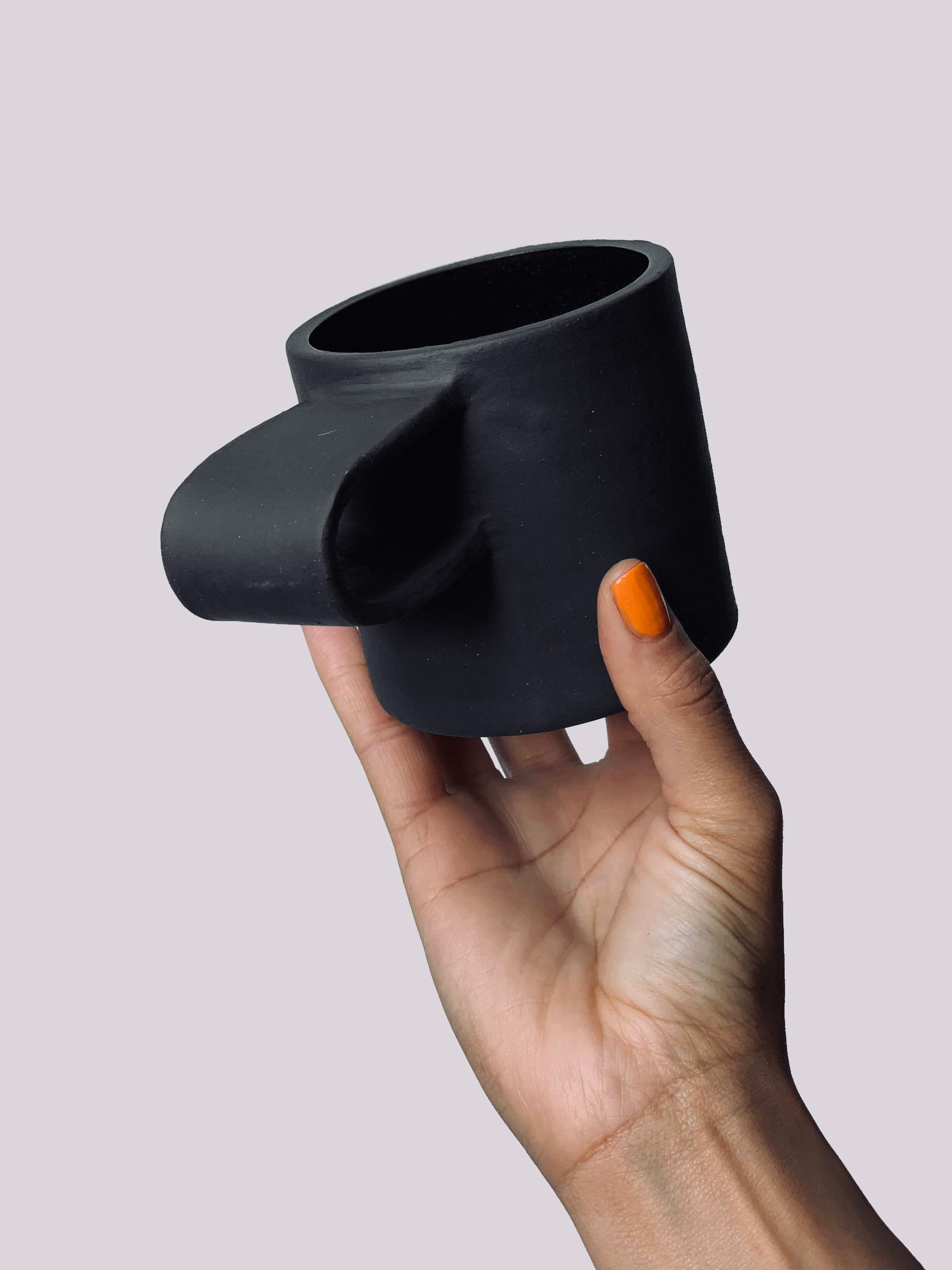 Black matte stoneware ceramic mug with a ribbon fold over handle.