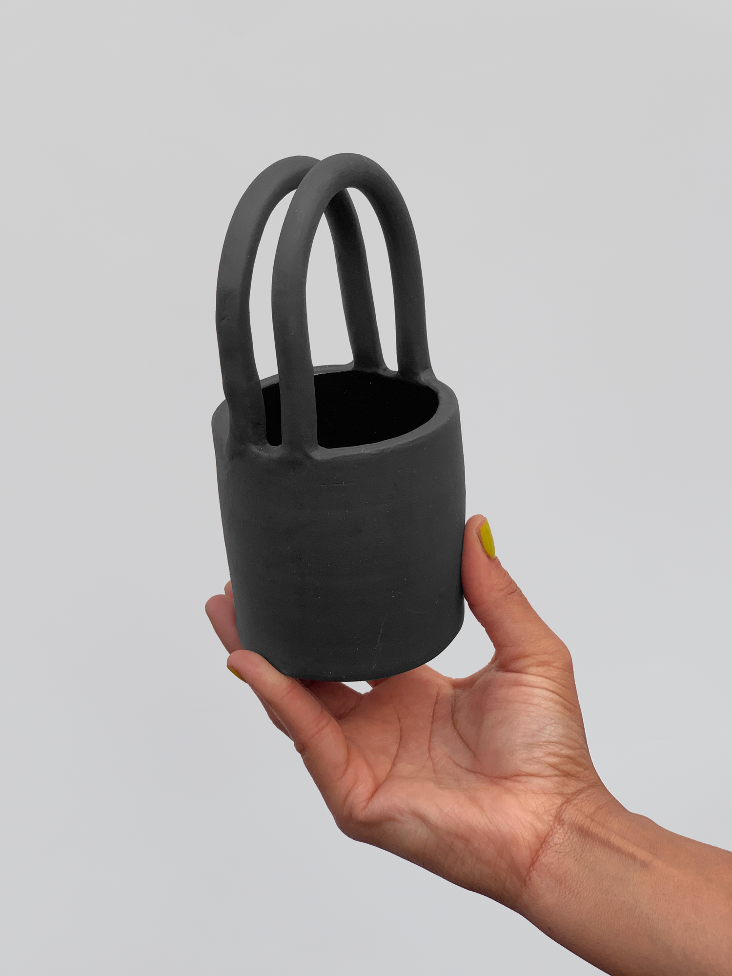 Black matte stoneware ceramic mug with tote bag handles.