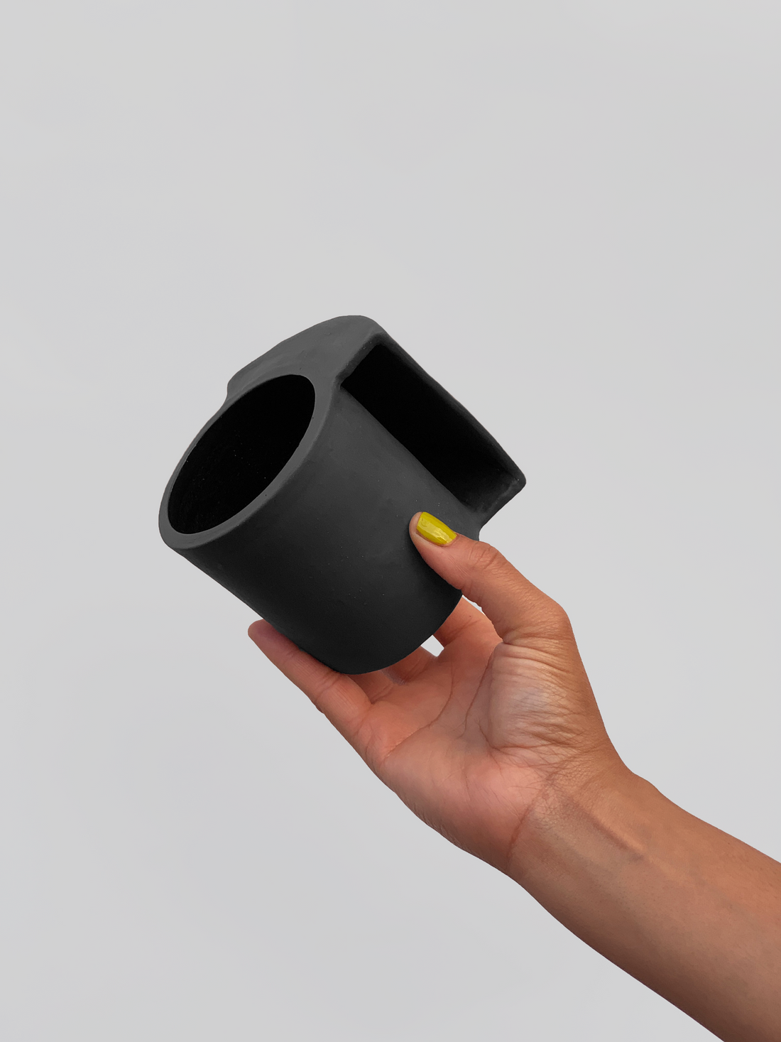 Black matte stoneware ceramic mug with a wide inlet cove handle.