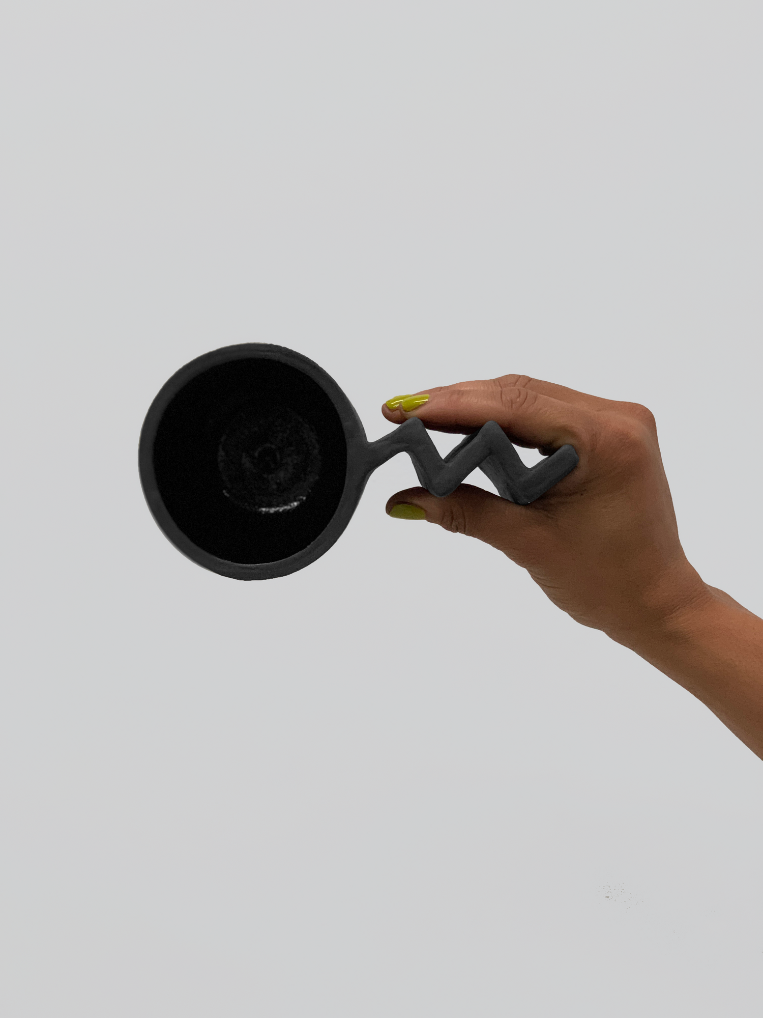 Black matte stoneware ceramic mug with extended zig zag handle.