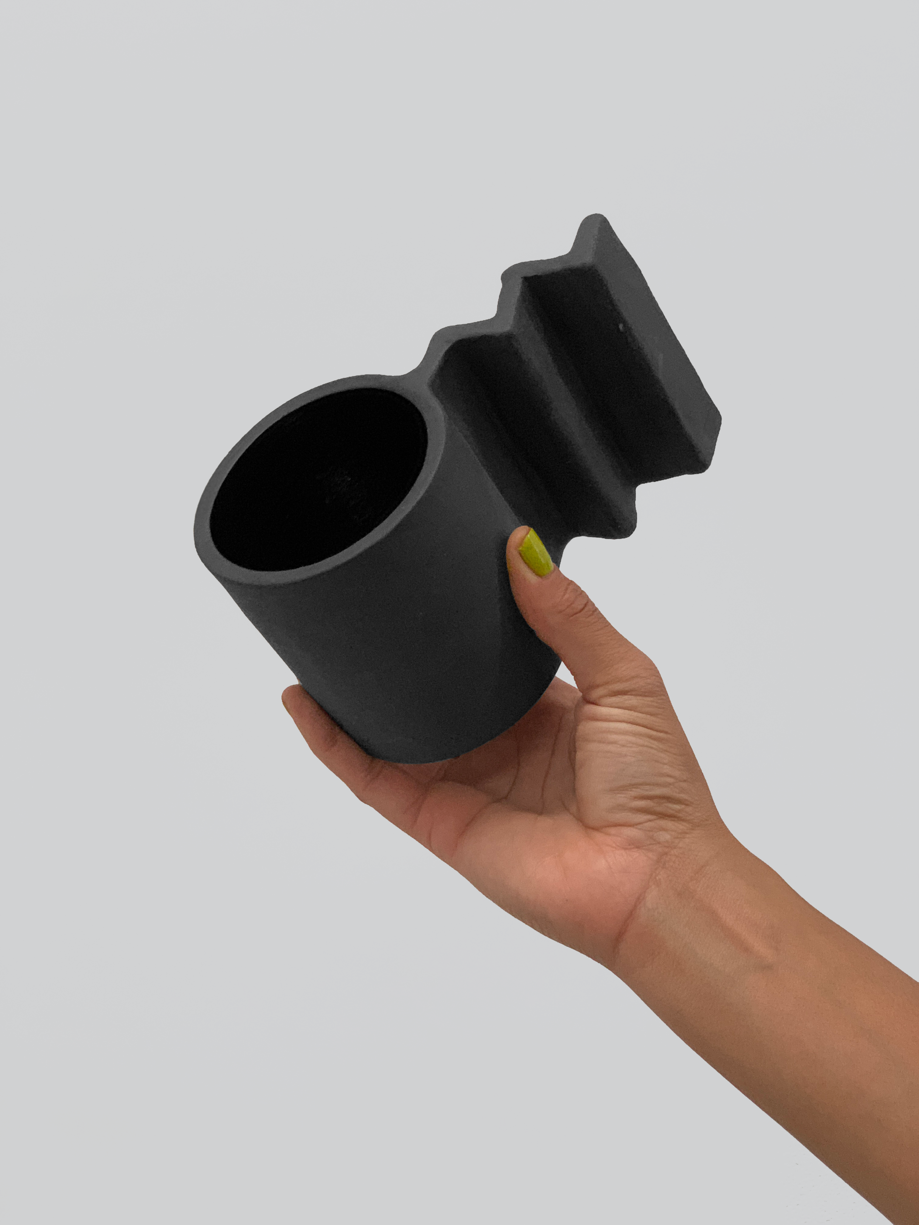 Black matte stoneware ceramic mug with extended zig zag handle.