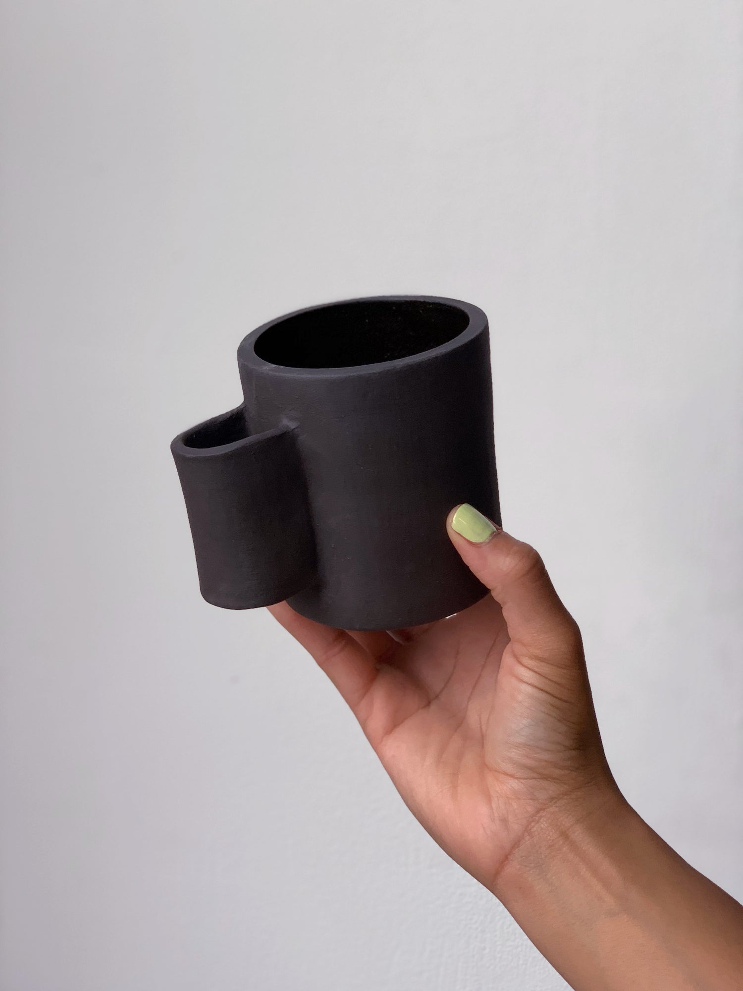 Black matte stoneware ceramic mug with tall u-shaped handle.