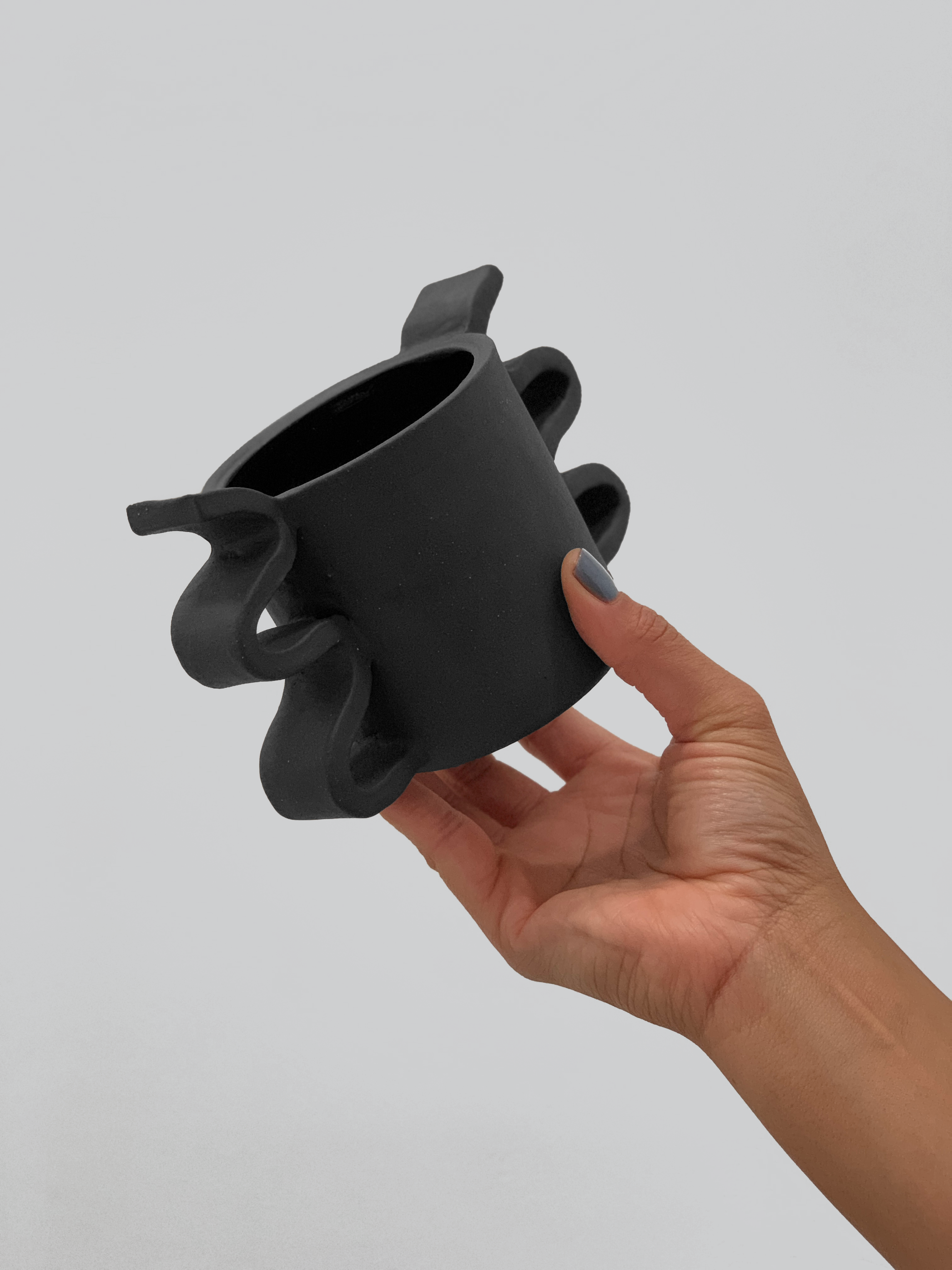 Black matte stoneware ceramic mug with double sided wide squiggle handles.
