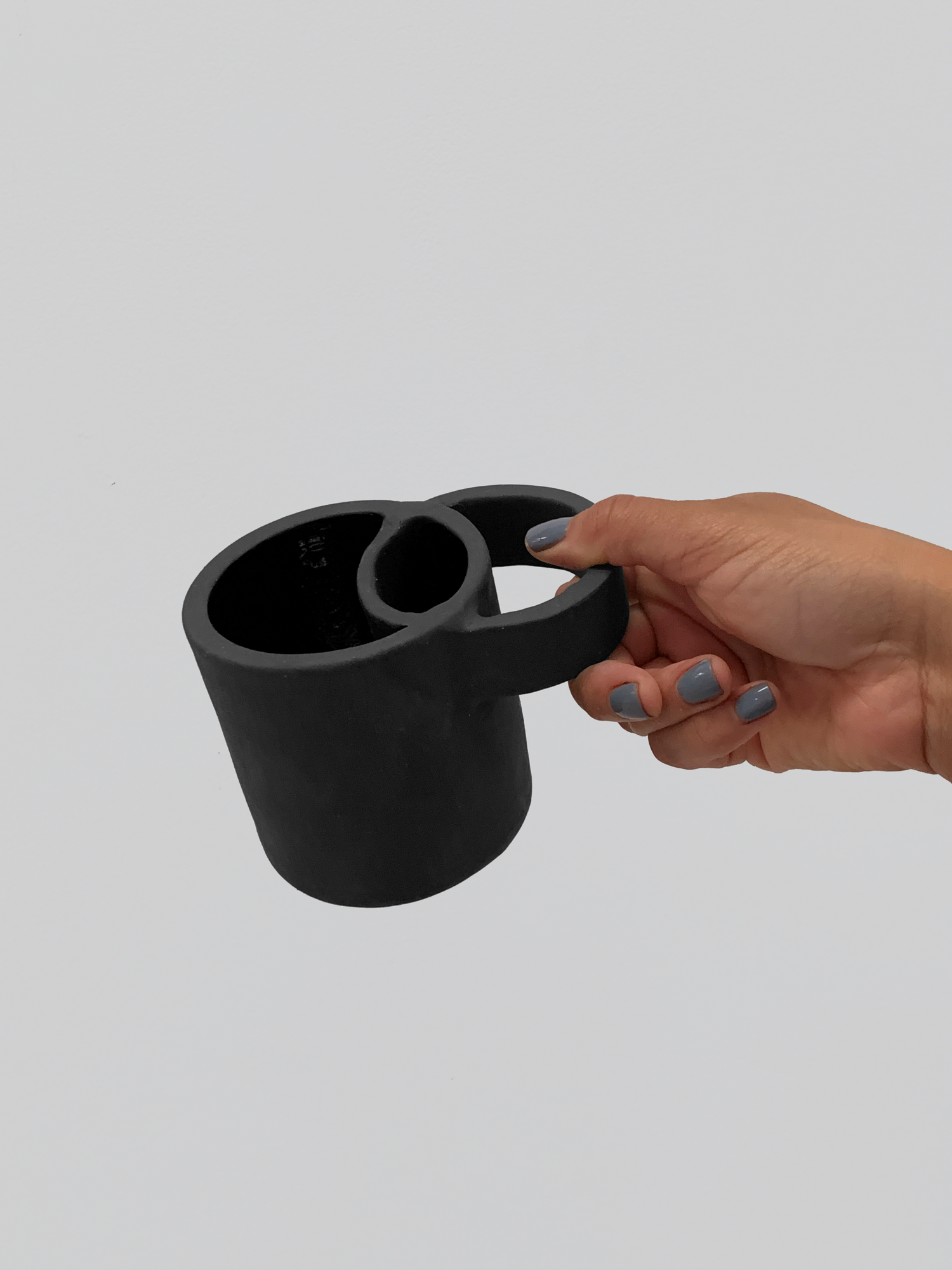 Black matte stoneware ceramic mug with wide overlapping circle handle.