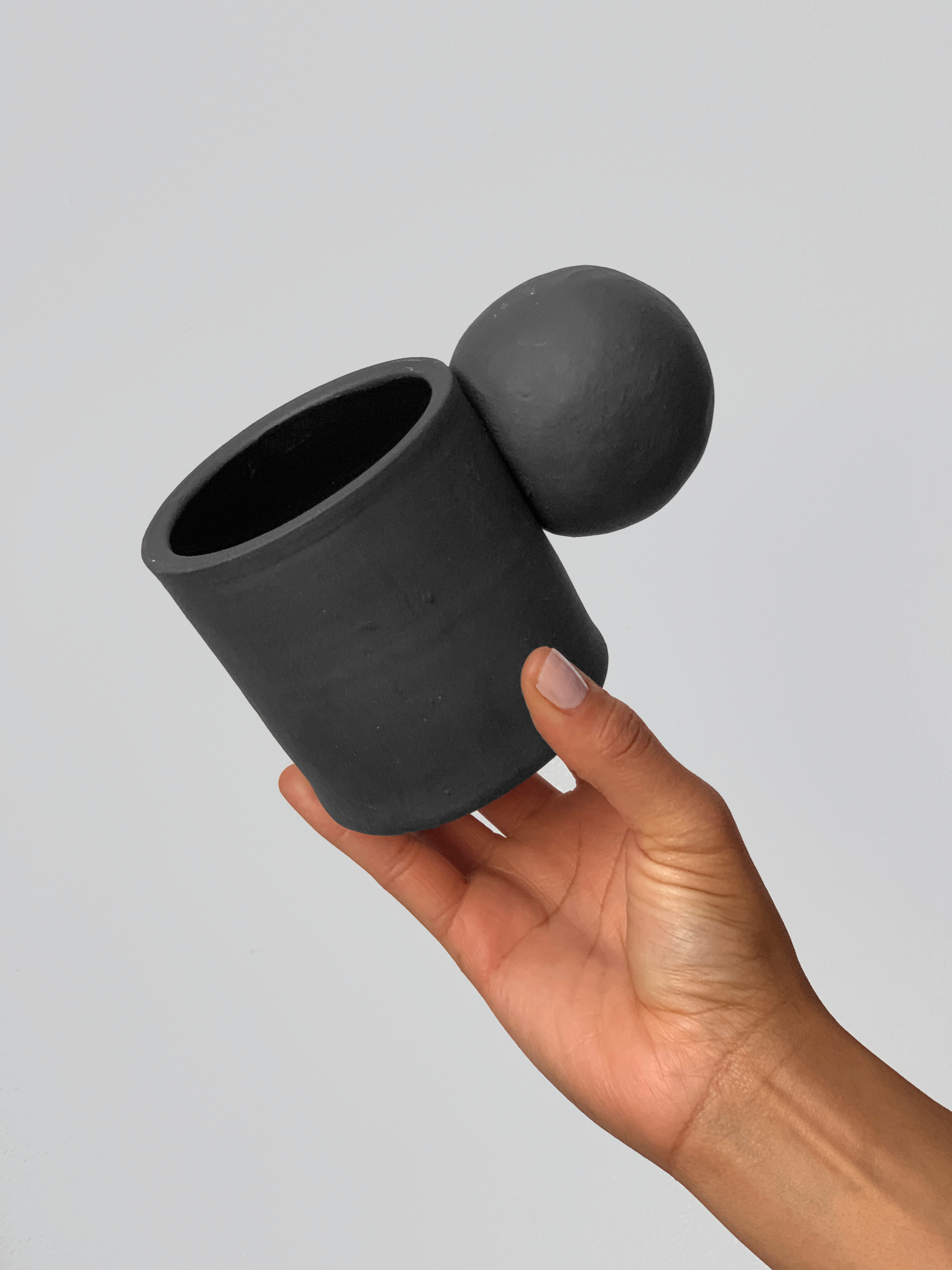 Black matte stoneware ceramic mug with extended ball shaped handle.