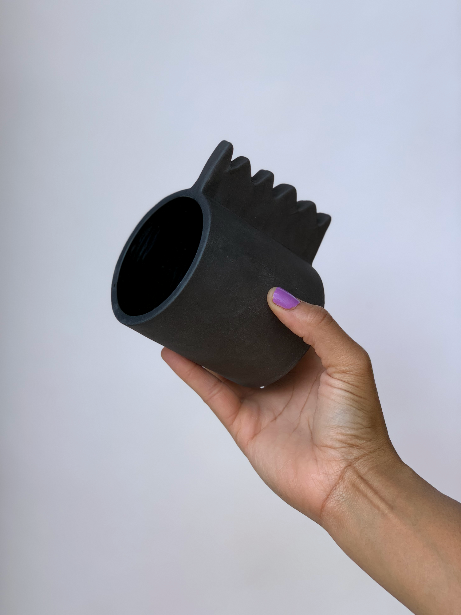 Black matte stoneware ceramic mug with a wide zigzag handle.