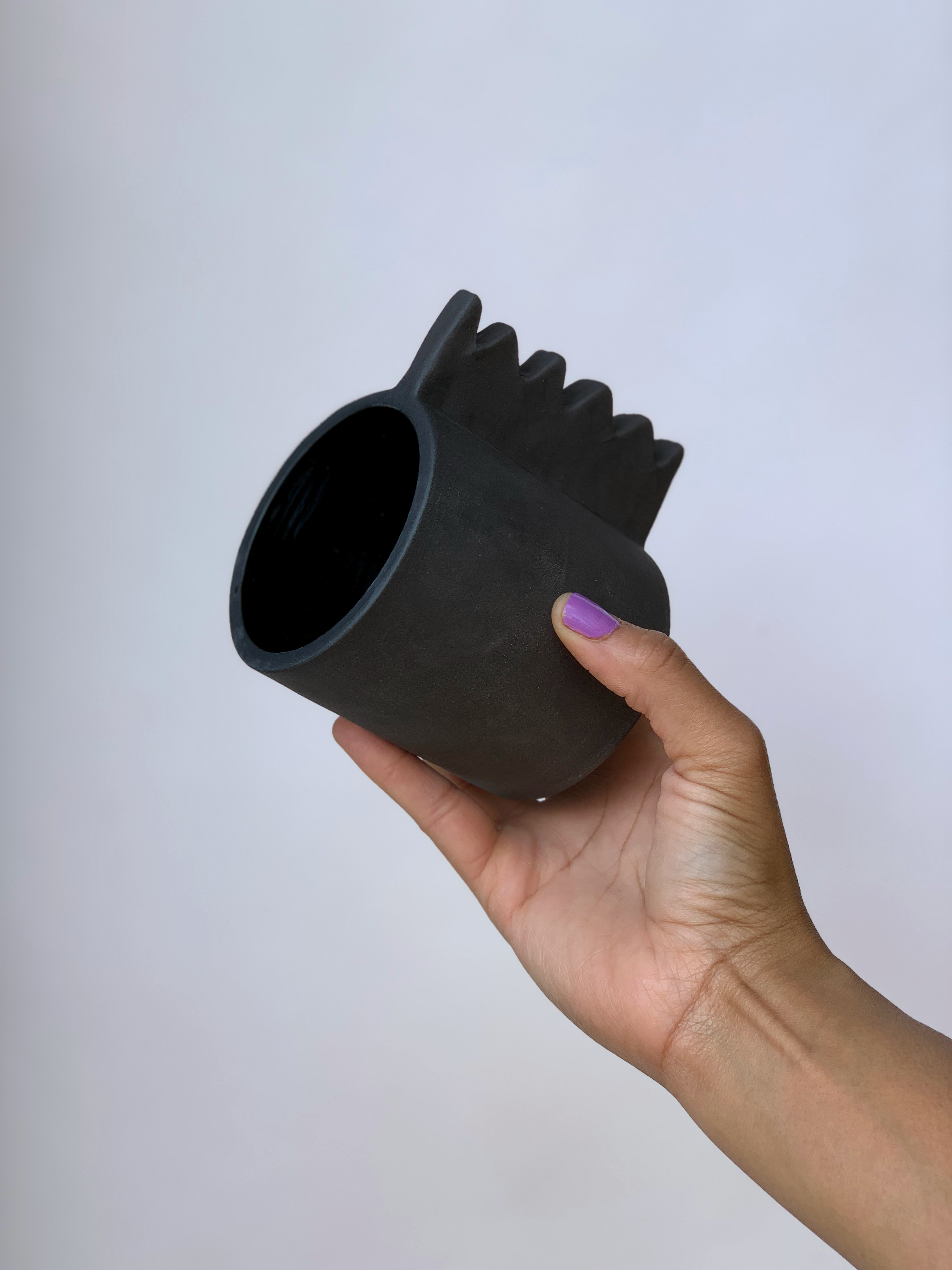 Black matte stoneware ceramic mug with a wide zigzag handle.