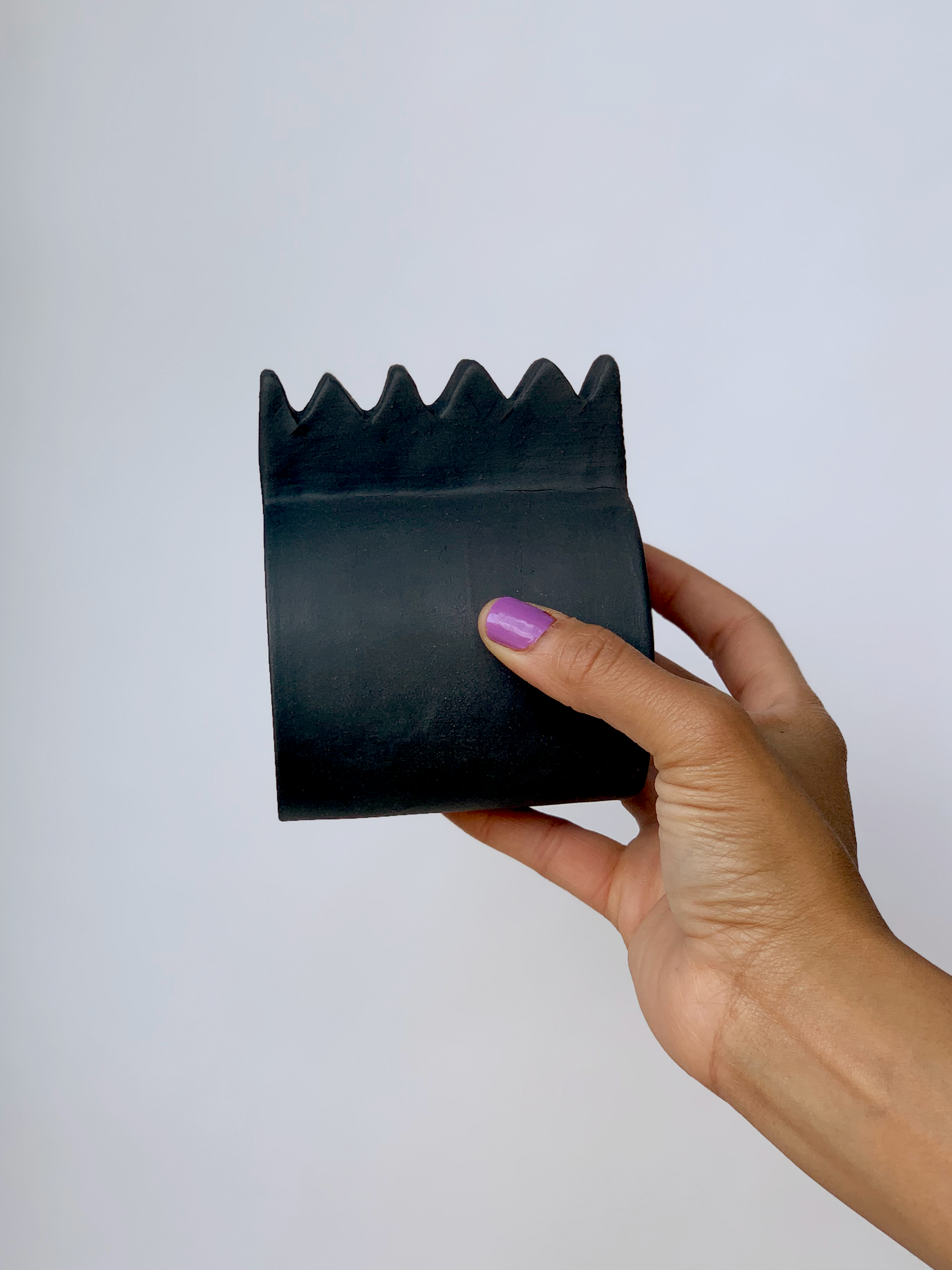 Black matte stoneware ceramic mug with a wide zigzag handle.