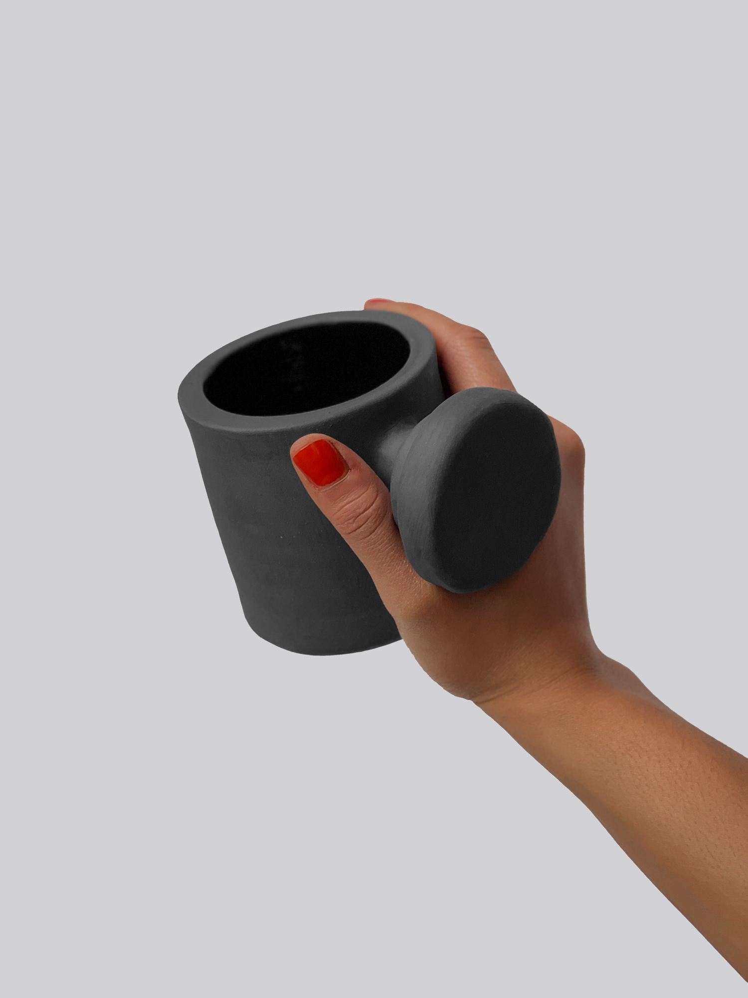 Black matte stoneware ceramic mug with a layered circular knob handle.