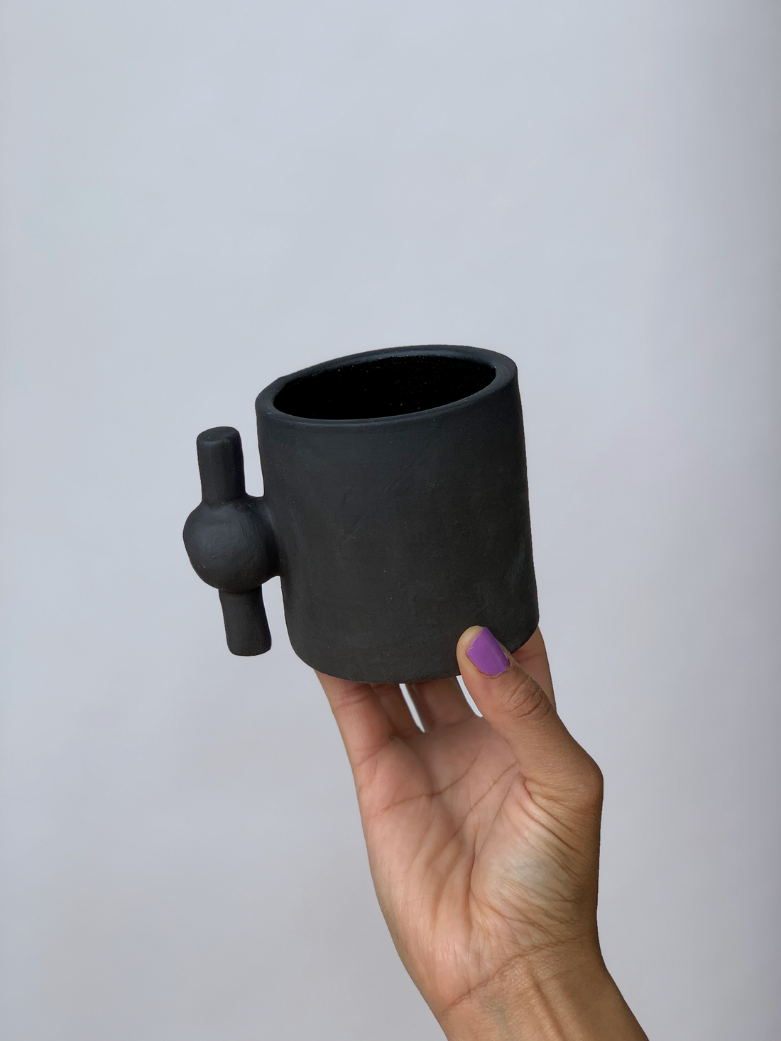 Black matte stoneware ceramic mug with a spigot handle.