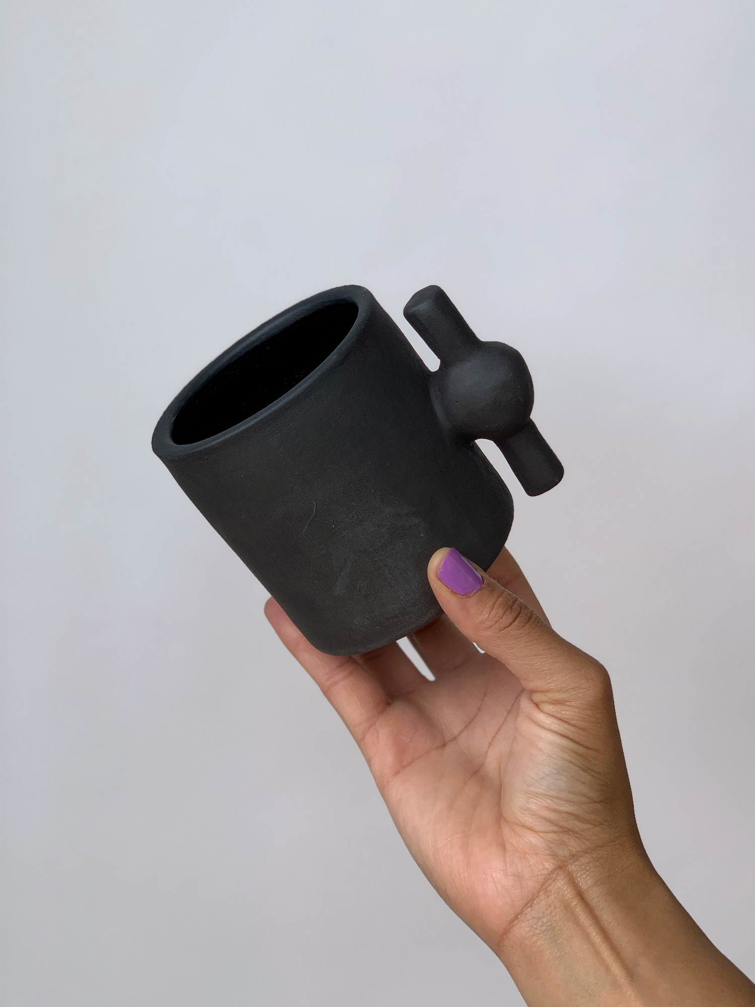 Black matte stoneware ceramic mug with a spigot handle.