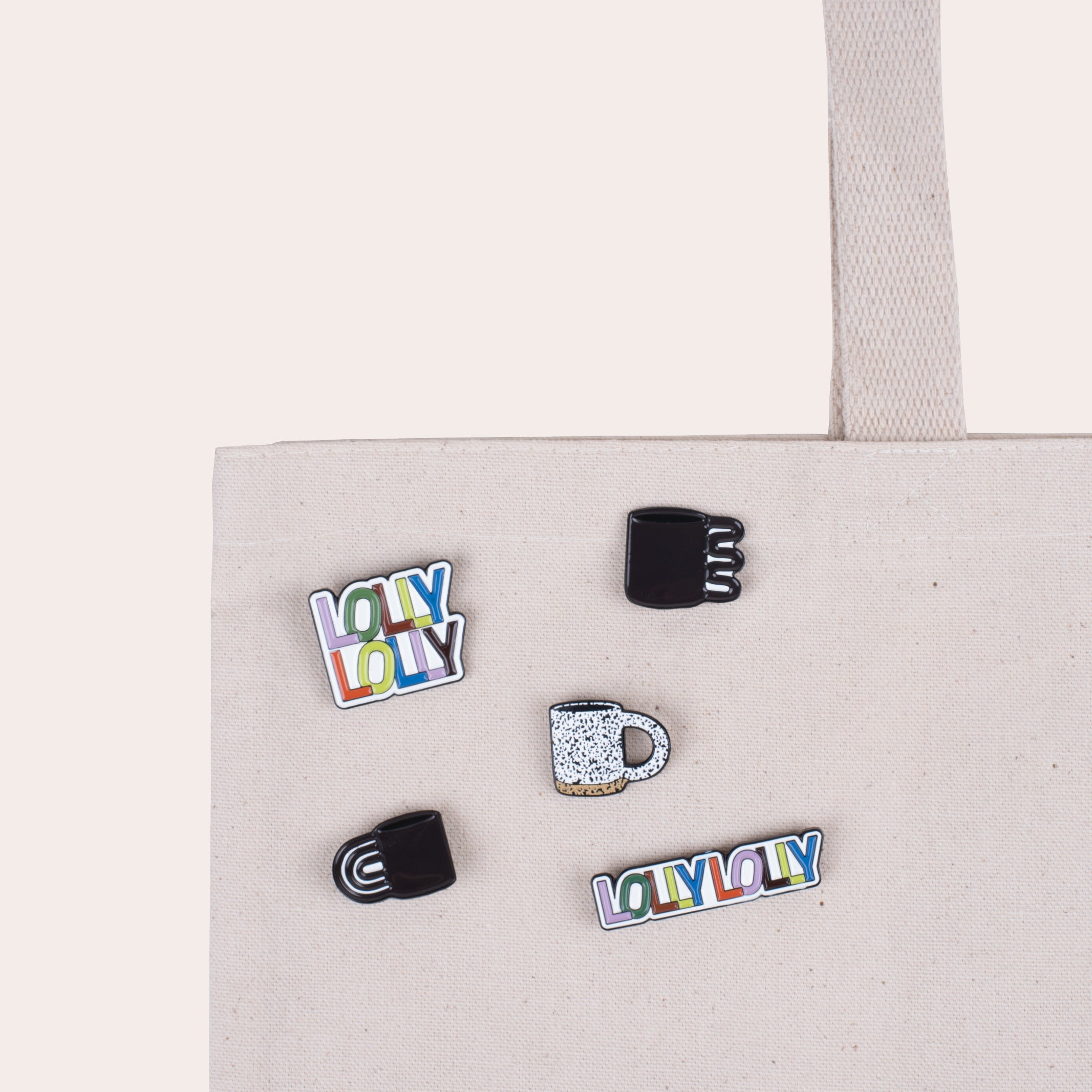 A soft enamel pin that reads "Lolly Lolly" in colorful letters with PVC rubber back.