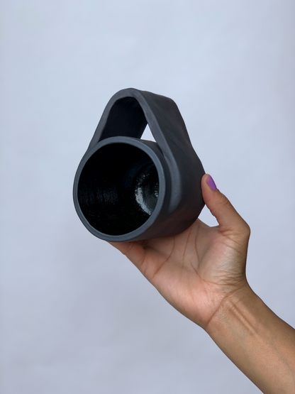 Black matte stoneware ceramic mug with a wide wrap around handle.