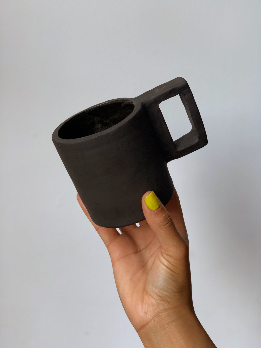 Black matte stoneware ceramic mug with a rectangle handle.