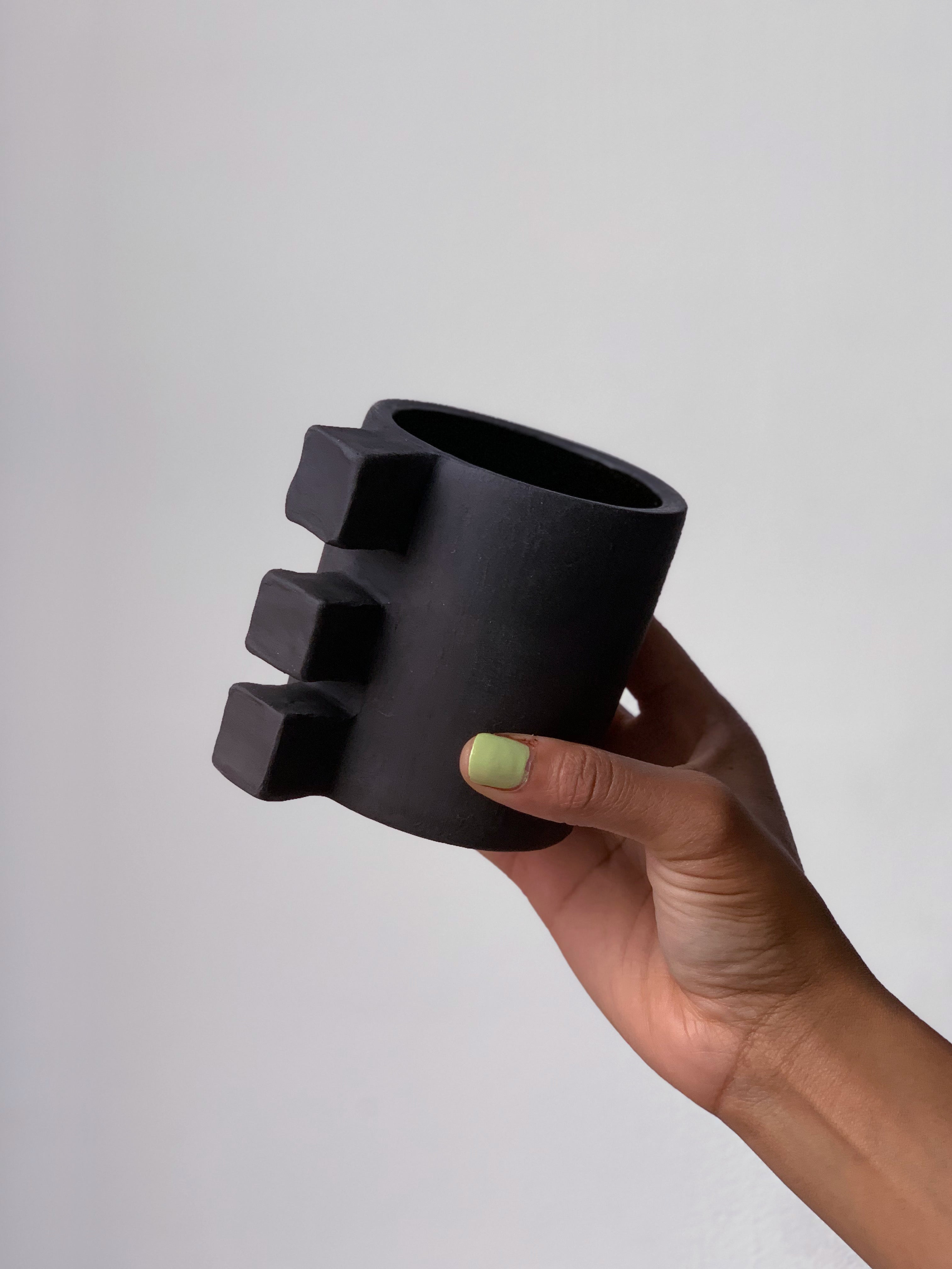 Black matte stoneware ceramic mug with three squares for the handle.