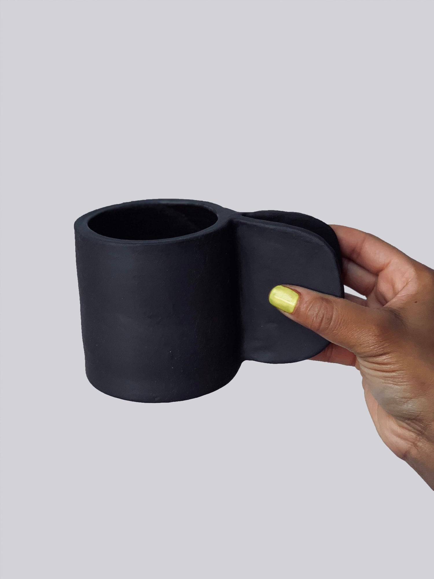 Black matte stoneware ceramic mug with extended clip handle.