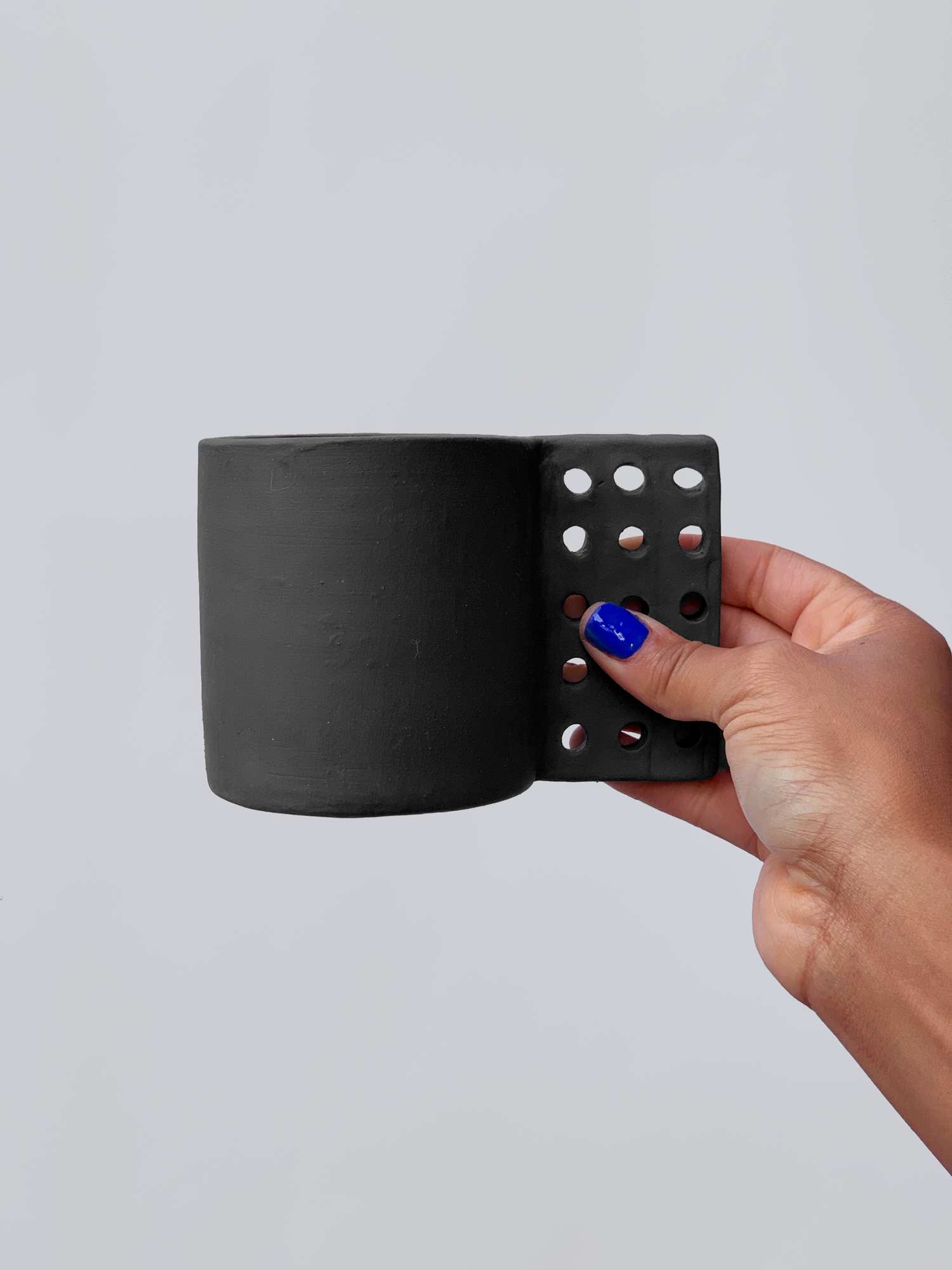 Black matte stoneware ceramic mug with a square dotted grid handle.
