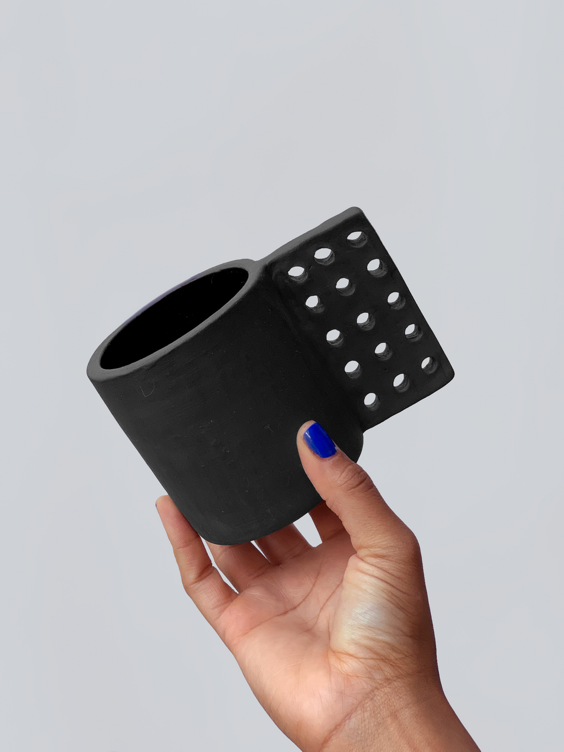 Black matte stoneware ceramic mug with a square dotted grid handle.