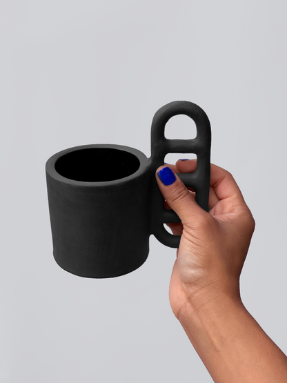 Black matte stoneware ceramic mug with an oval window handle.