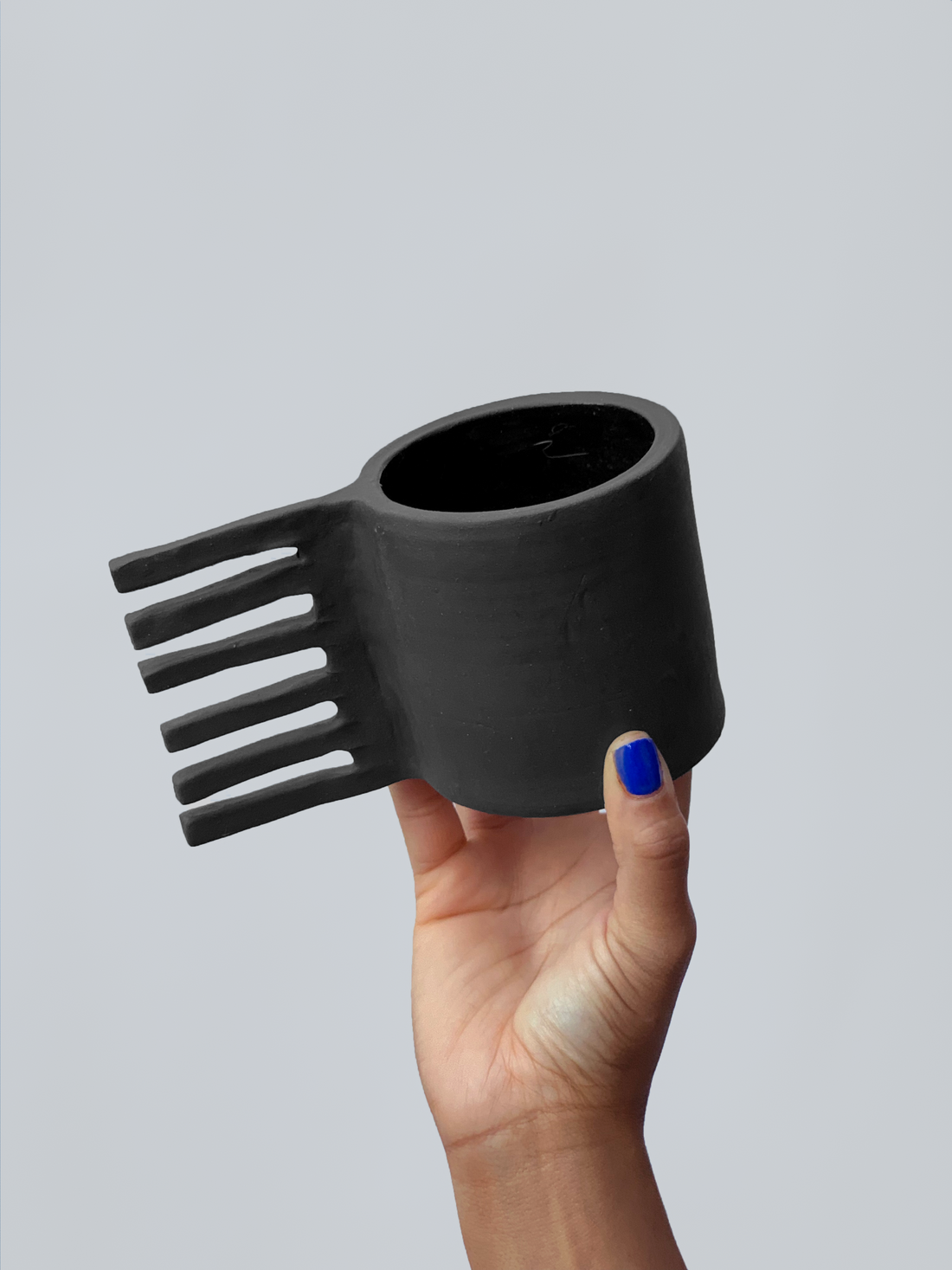 Black matte stoneware ceramic mug with six long square bars as the handle.