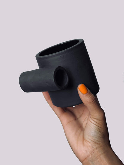 Black matte stoneware ceramic mug with a full side roll as the handle.
