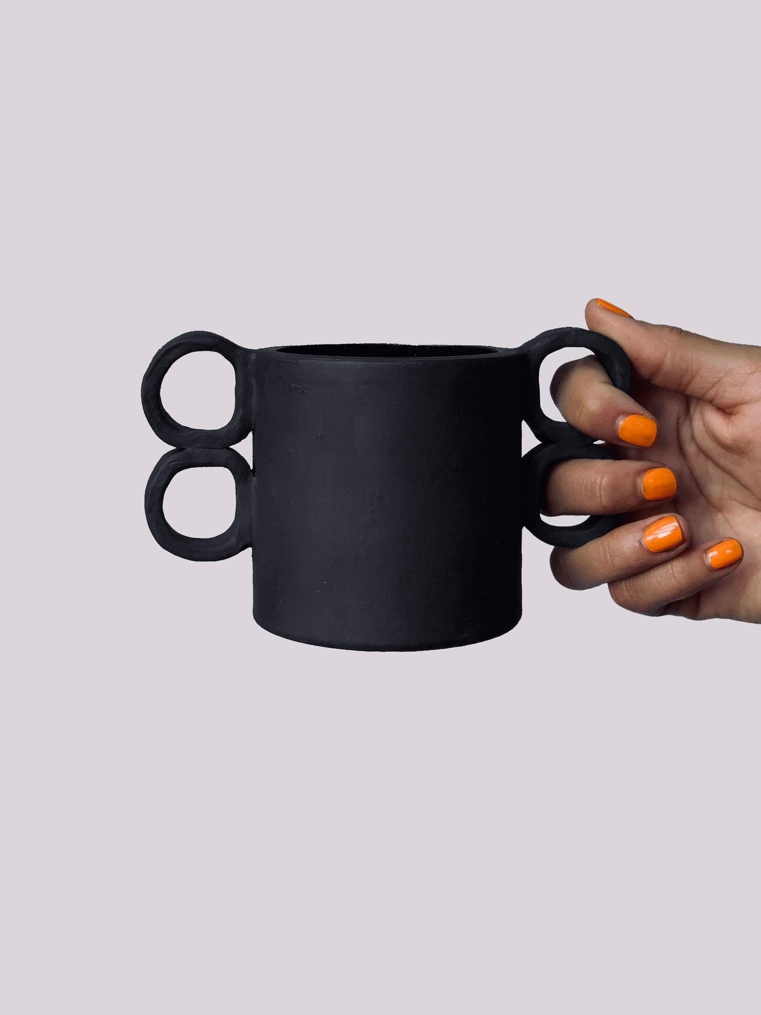 Black matte stoneware ceramic mug with double sided finger hole handles. 