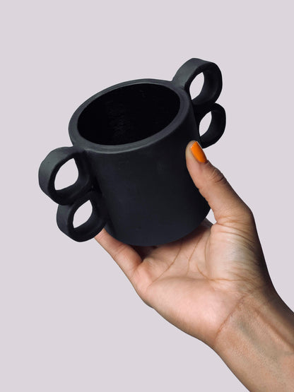Black matte stoneware ceramic mug with double sided finger hole handles.