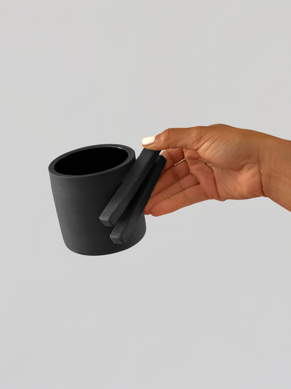 Black matte stoneware ceramic mug with two long rectangle shapes on the side of the mug as the handle.