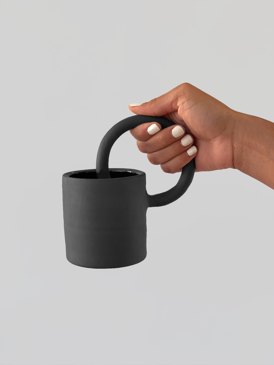 Black matte stoneware ceramic mug with a full circle through center handle.