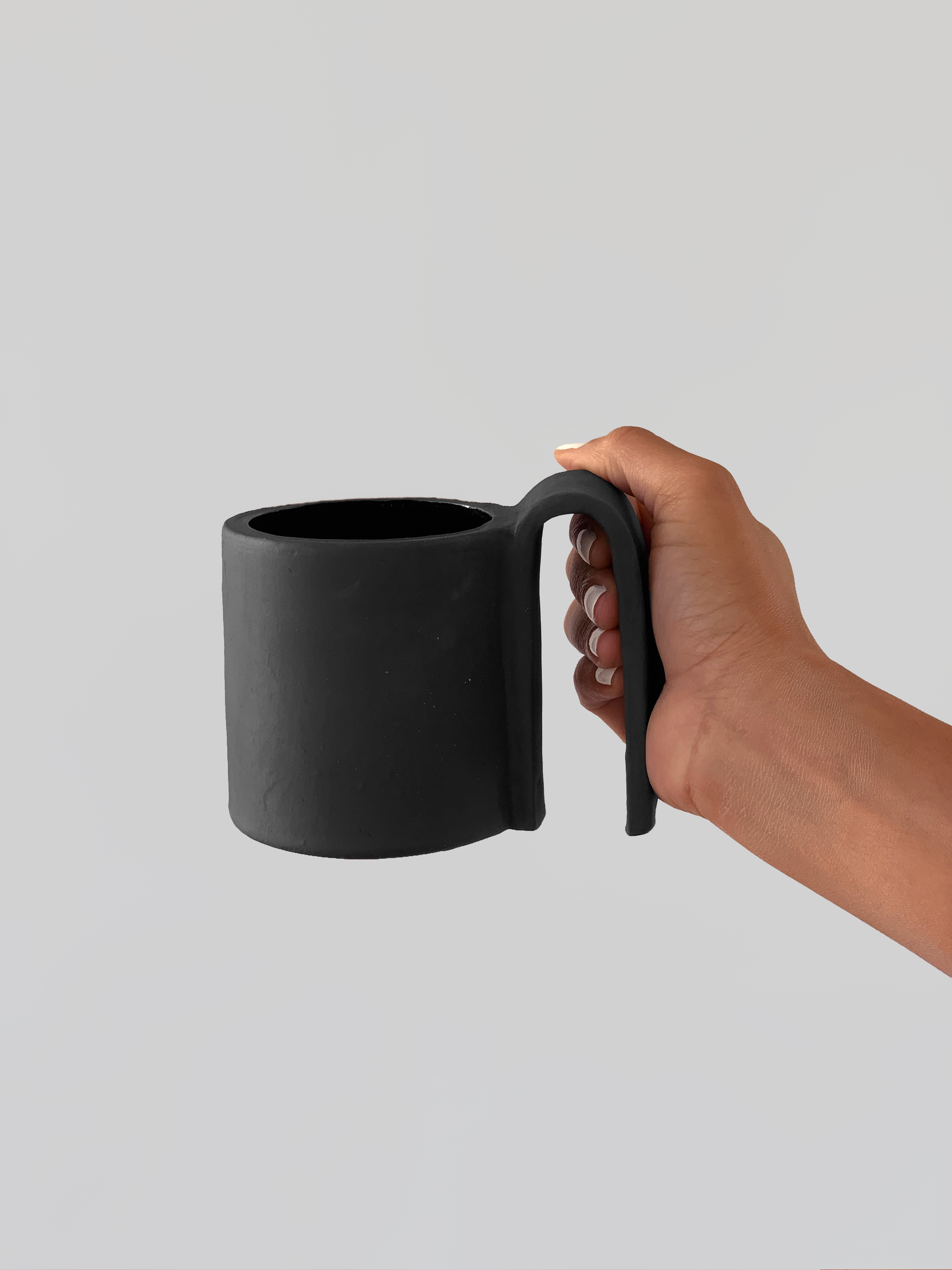 Black matte stoneware ceramic mug with a  wide long full fold over handle.