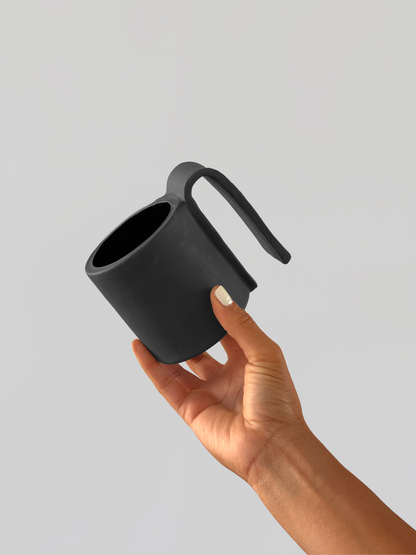 Black matte stoneware ceramic mug with a wide long full fold over handle.