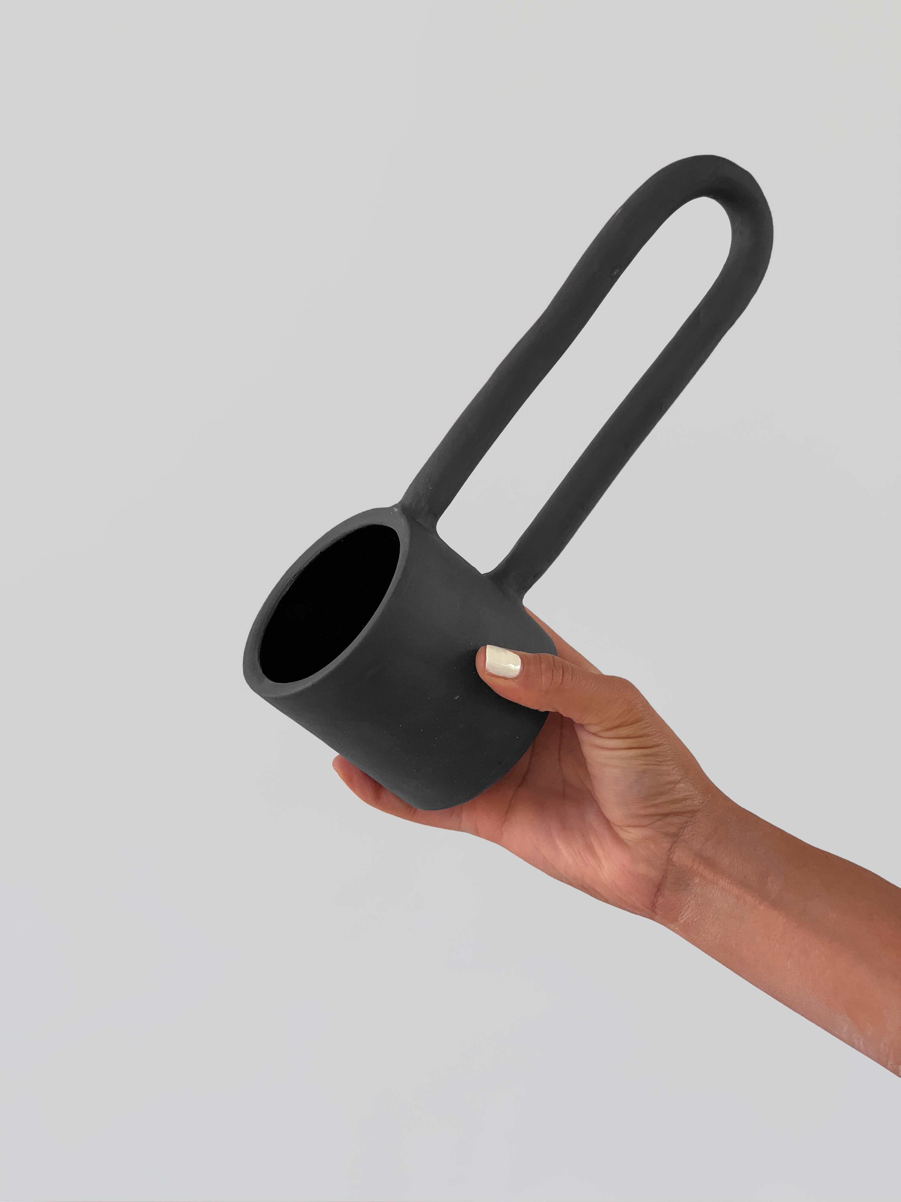 Black matte stoneware ceramic mug with a n extra long half circle handle.