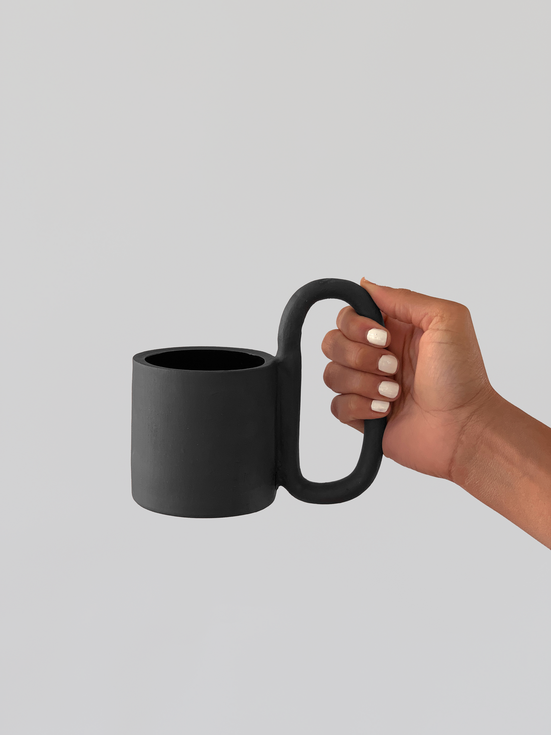 Black matte stoneware ceramic mug with a n extended oval handle.
