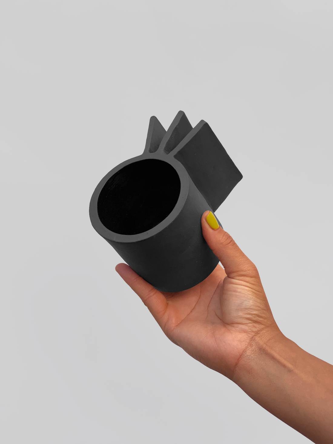 Black matte stoneware ceramic mug with three flat extended squares as the handle.