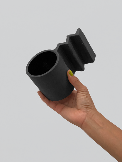 Black matte stoneware ceramic mug with extended zig zag handle.