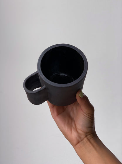 Black matte stoneware ceramic mug with tall u-shaped handle. 