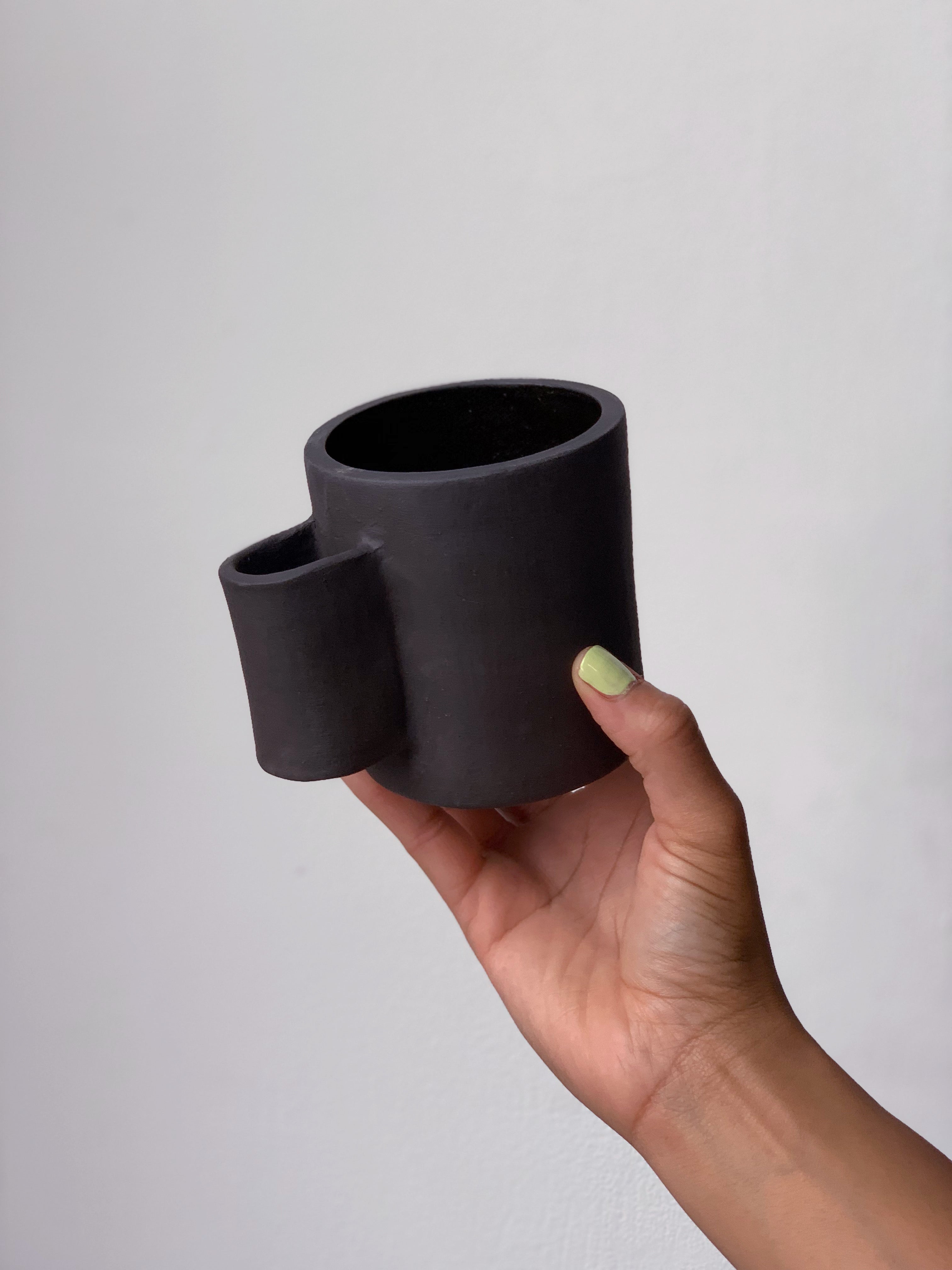 Black matte stoneware ceramic mug with tall u-shaped handle. 
