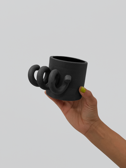 Black matte stoneware ceramic mug with a thick side spiral handle.