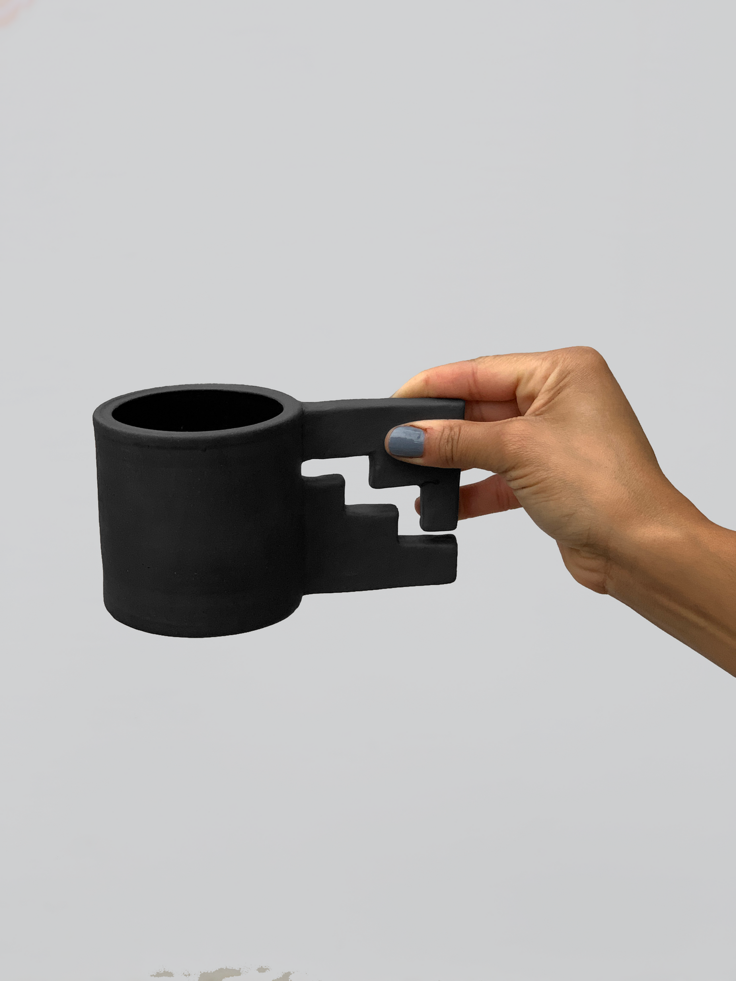 Black matte stoneware ceramic mug with an enclosed thunderbolt handle.