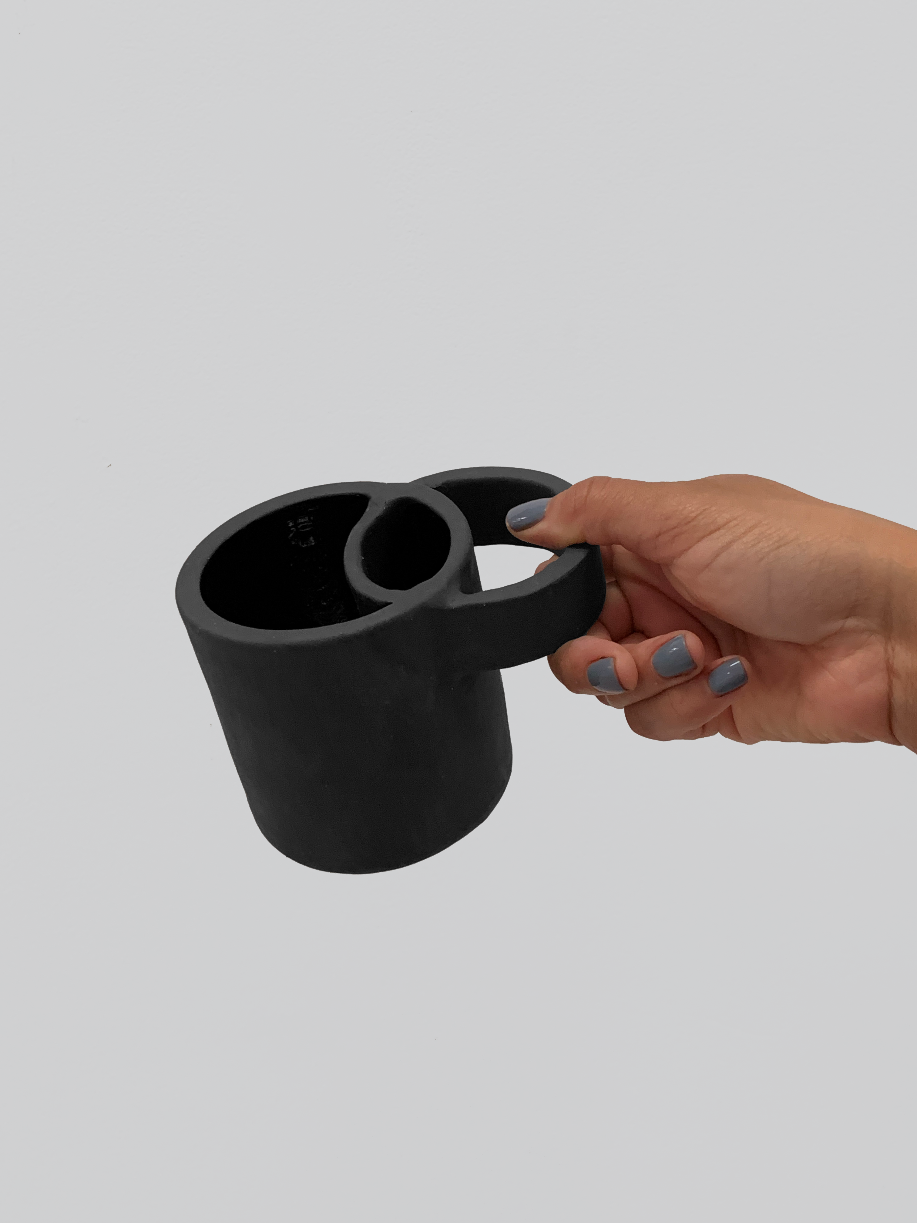 Black matte stoneware ceramic mug with wide overlapping circle handle.