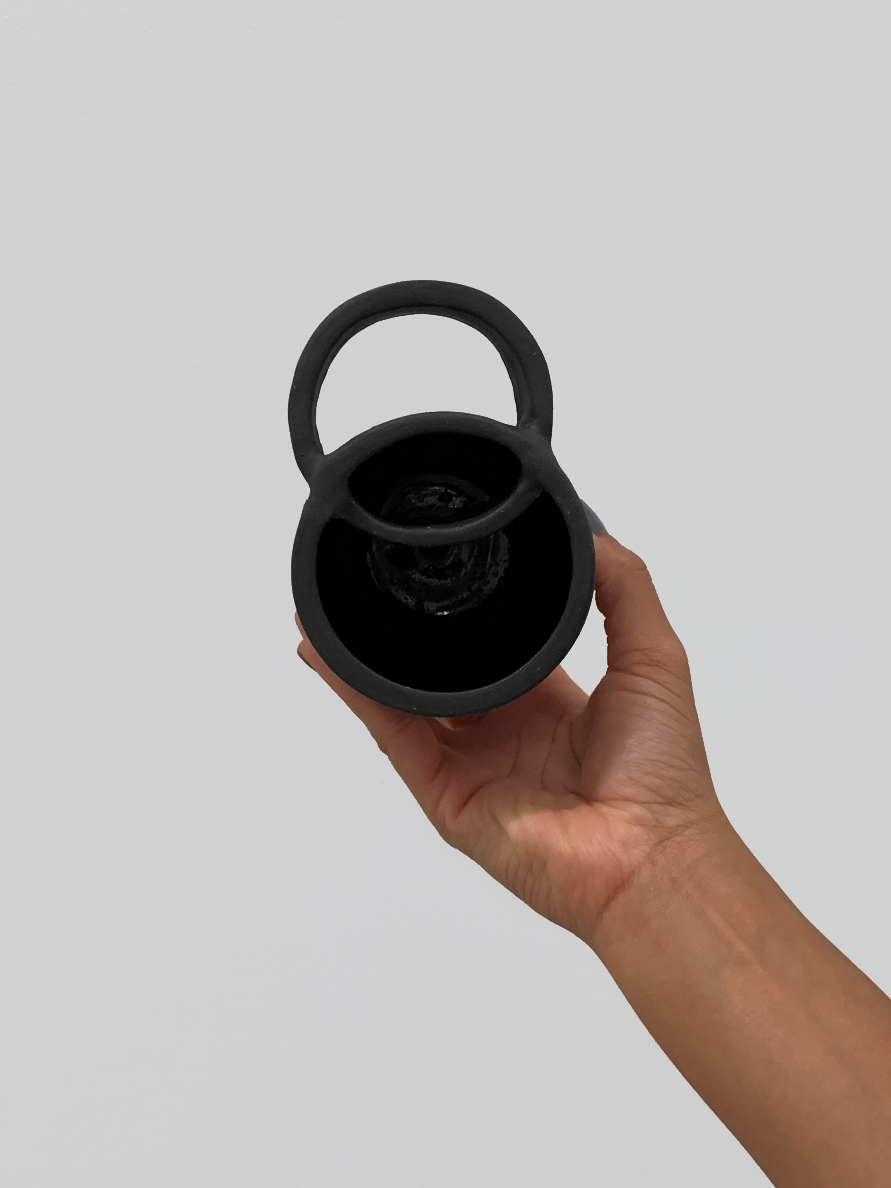 Black matte stoneware ceramic mug with wide overlapping circle handle.