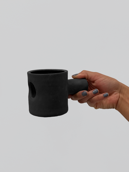 Black matte stoneware ceramic mug with a cylinder through the mug and extending out as the handle.