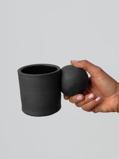 Black matte stoneware ceramic mug with extended ball shaped handle.