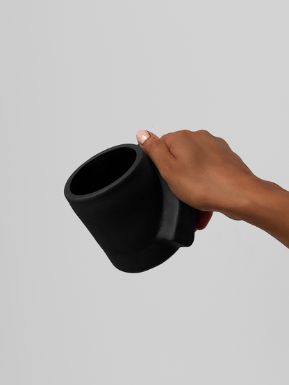 Black matte stoneware ceramic mug with thick sloped rectangle side handle.